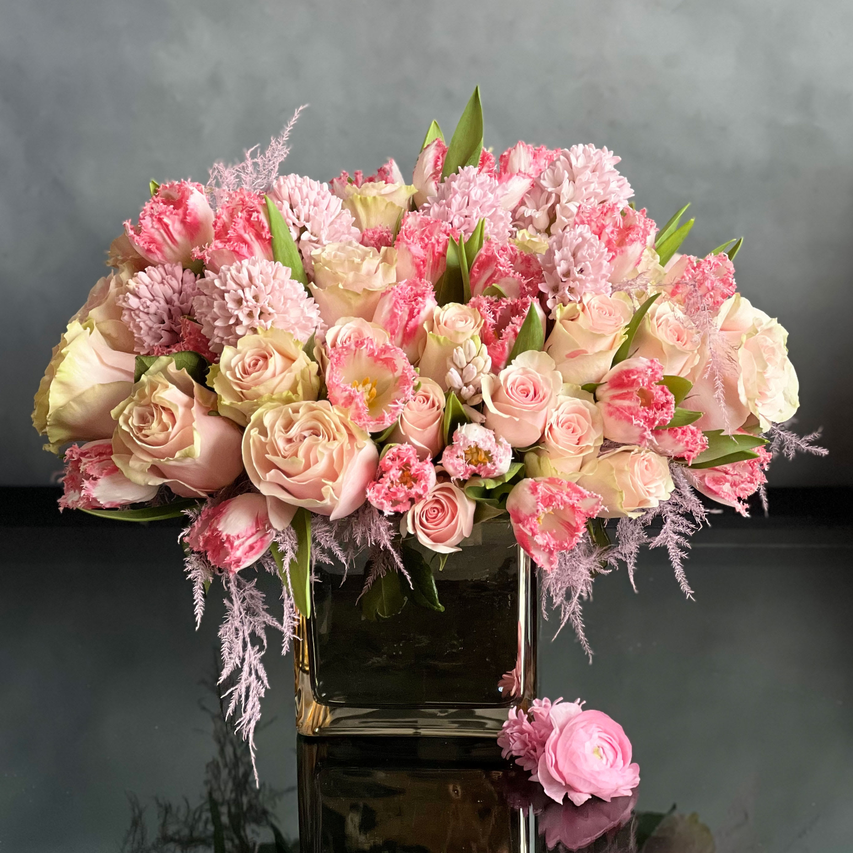 Sweet Embrace - Delightful and enchanting.  An absolutely perfect pastel mix of luscious pink roses, pink  hyacinth, pale pink fringe tulips, and pink dried accents are beautifully displayed in a glass vase. Breathtaking appeal and sweet floral scents make these beautiful blooms a truly splendid gift!  