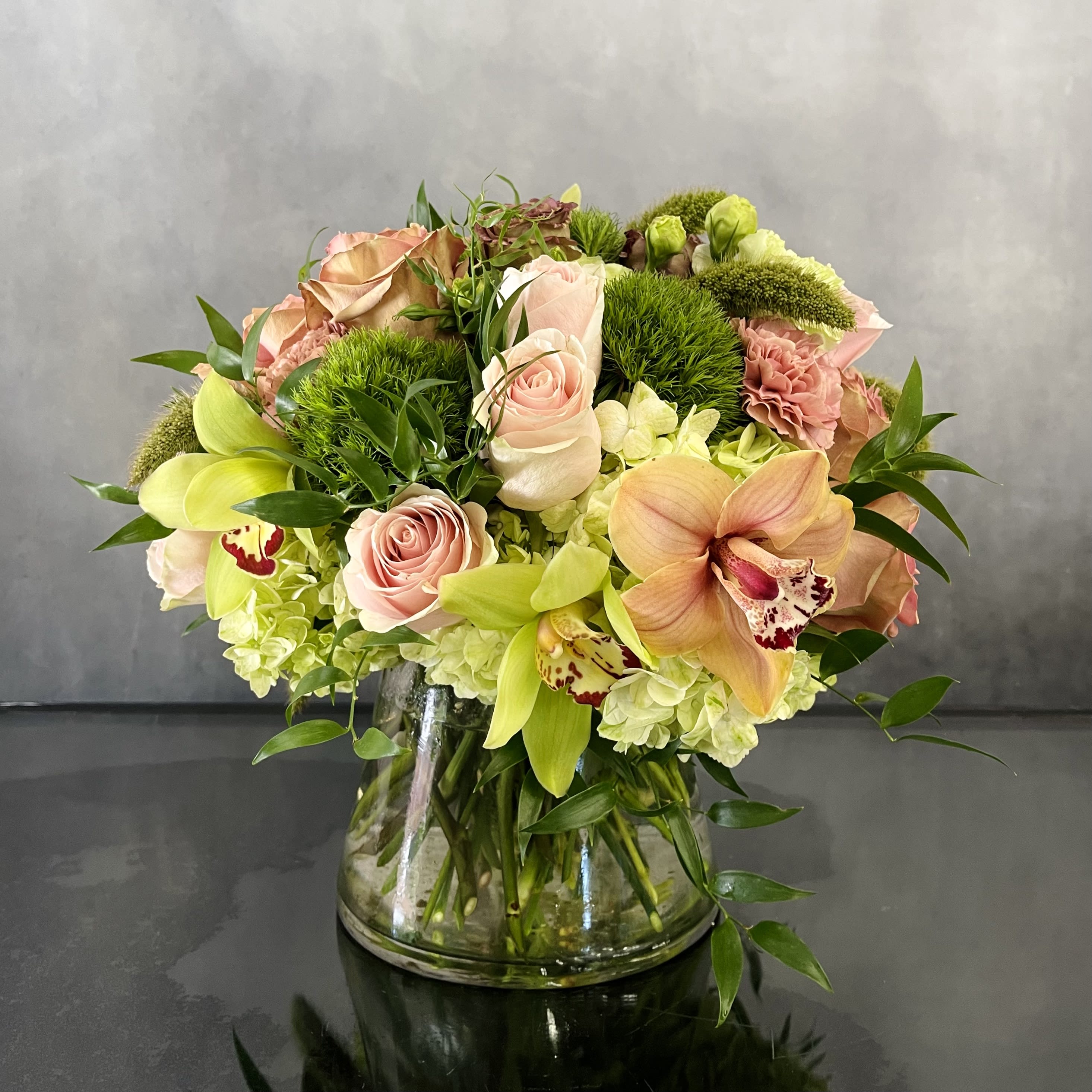 Mini Garden  - A mini version of a pink Rose Garden. This arrangement consists of Green and Peach Cymbidium Orchids, Green Hydrangeas and Dianthus. All paired together with pink Roses. A small and simple way to say thank you ! 