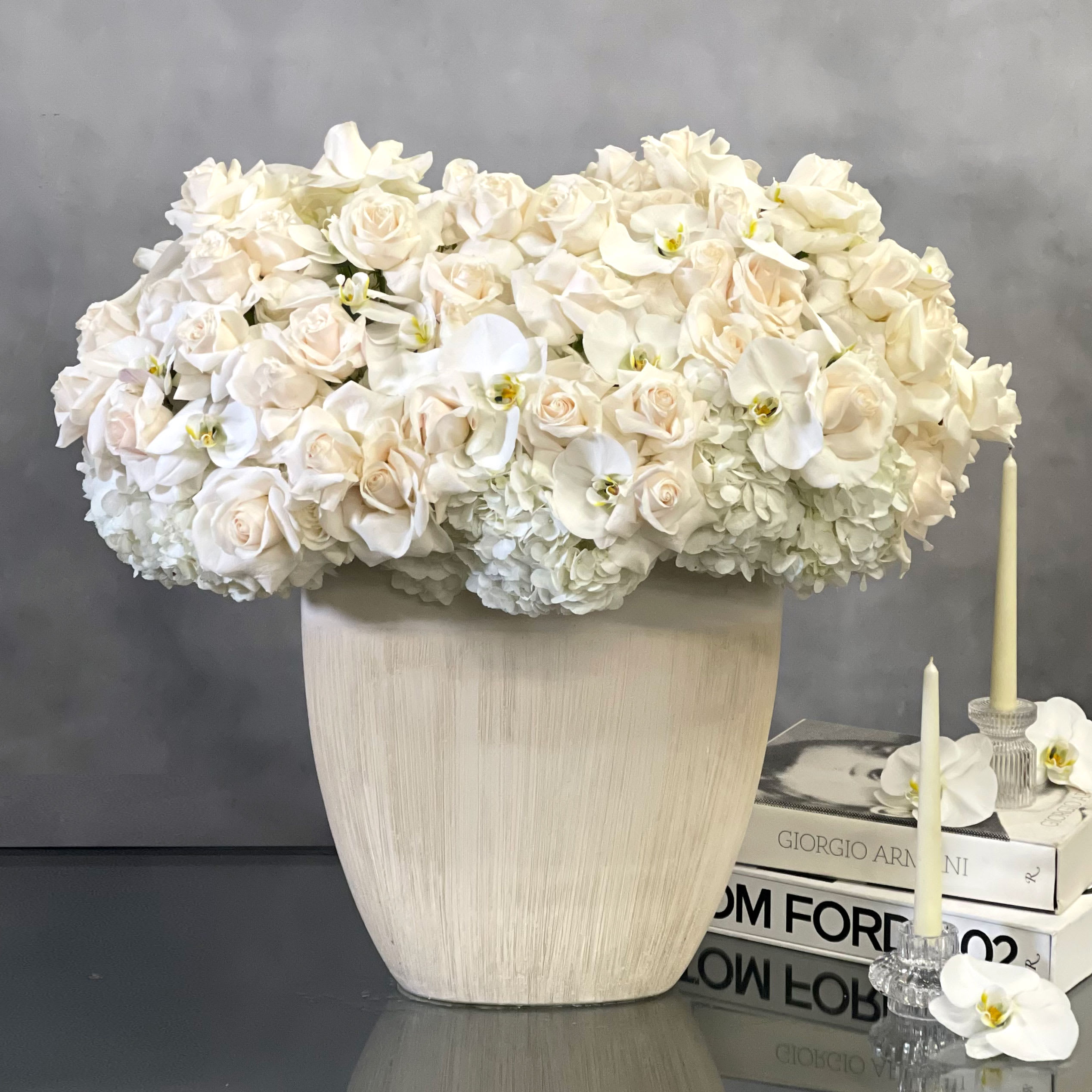 Grand Whites - Beverly Hills Florist presents these stunning, over 100 specialty white Ecuadorian, orchids, and hydrangeas  in a modern white vase. Clustered in a fresh, full and delicate arrangement, this simplistic style offers a timeless display of love. Same day delivery available for these gorgeous blooms, perfect for expressing love and romance, anniversaries, gratitude, surprises, and more!  