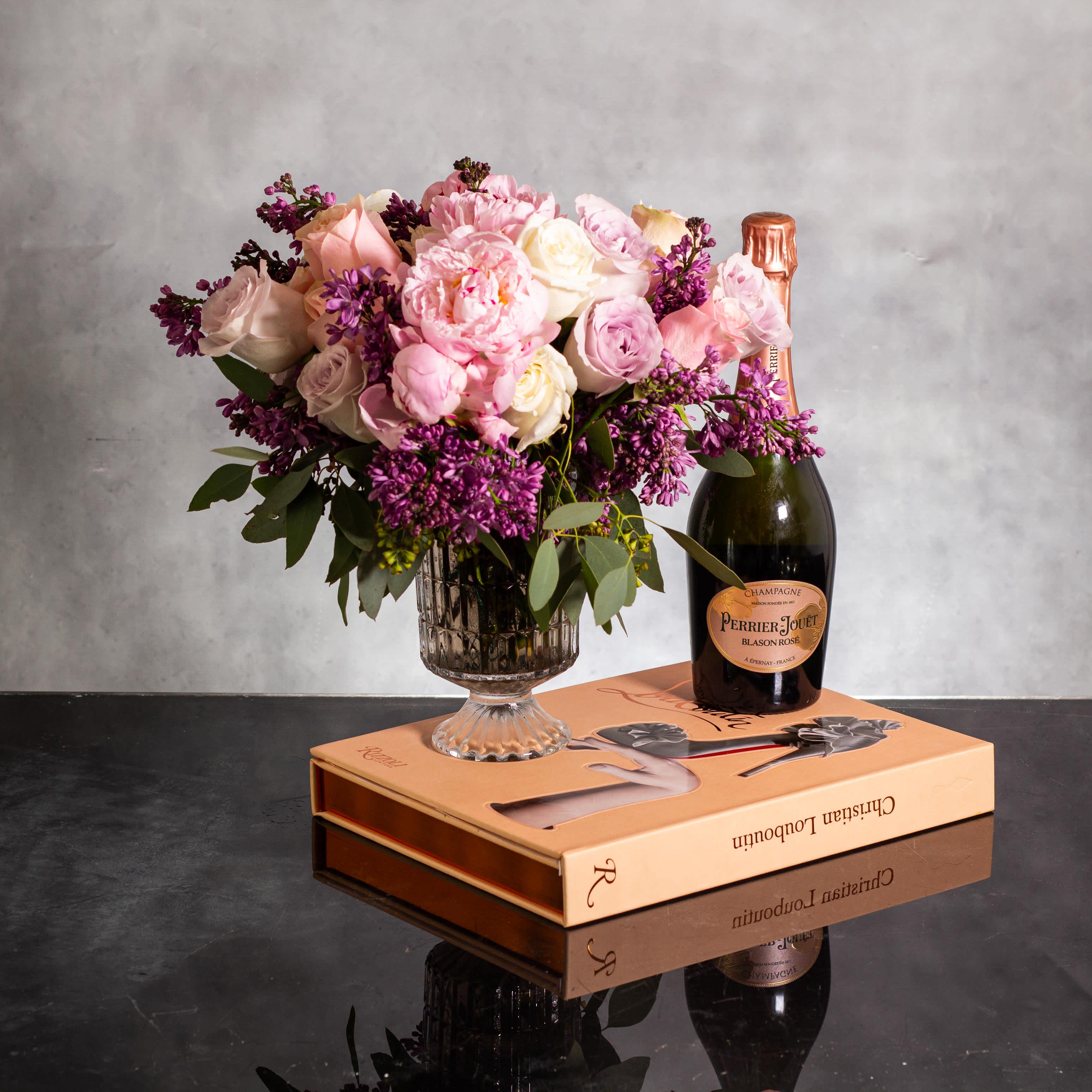 Luxury Blooms - The luxurious floral arrangement features peonies, spray roses, and lilac artfully arranged in a 7-inch footed glass vase. Standing at approximately 14 inches tall and 10 inches wide, this stunning display is perfect for any special occasion. The combination of peonies, spray roses, and lilac exudes luxury to the max, making it a beautiful centerpiece that is sure to impress.