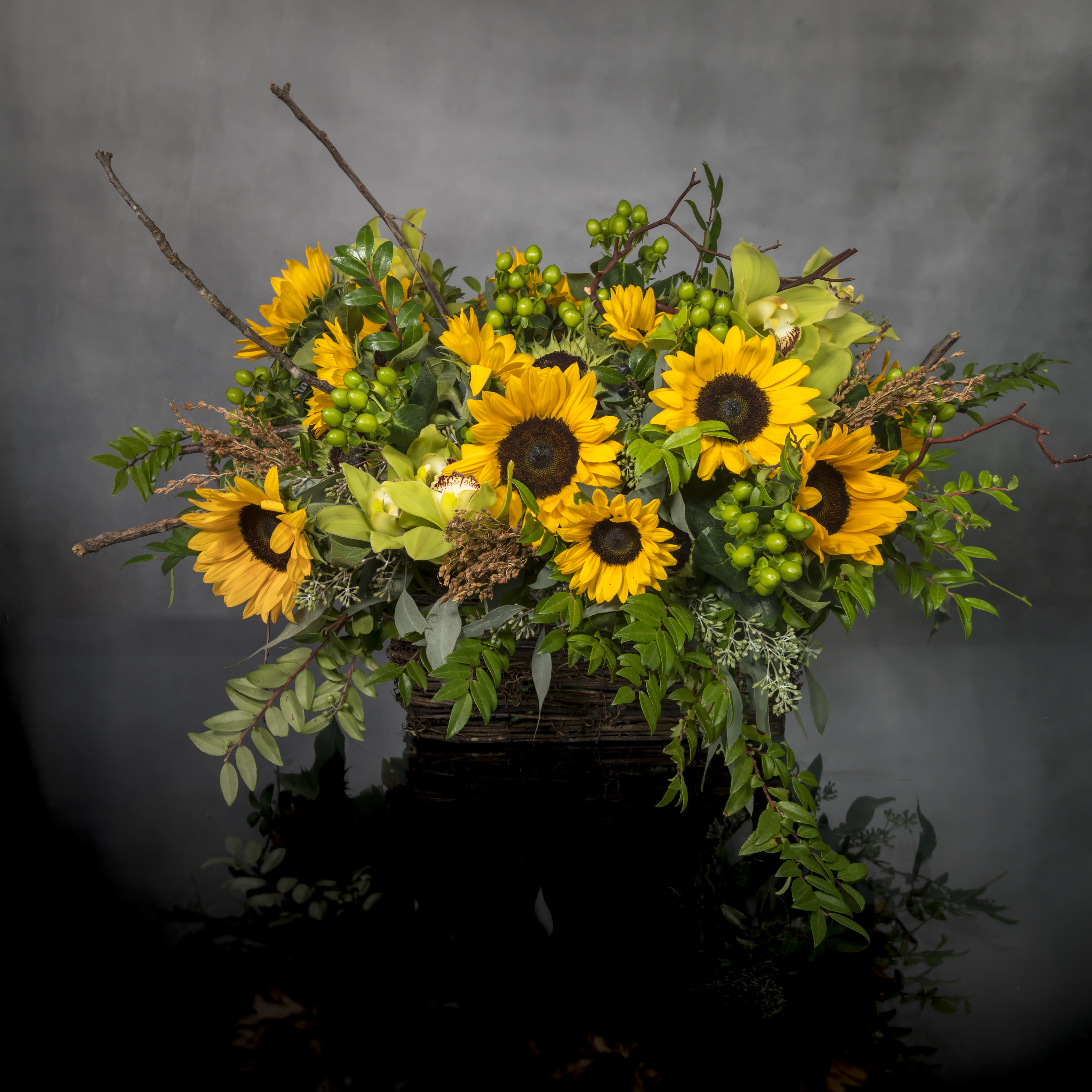 Under the Tuscan Sunflowers - Pasadena Florist - There’s so much about sunflowers that inspire and that’s why we’ve captured it all in one charming basket! Filled with a beautiful mix of yellow and green sunflowers and Cymbidium Orchids, this hand-designed arrangement will inspire your recipient to smile brighter, laugh longer... and delight in the moment forever.