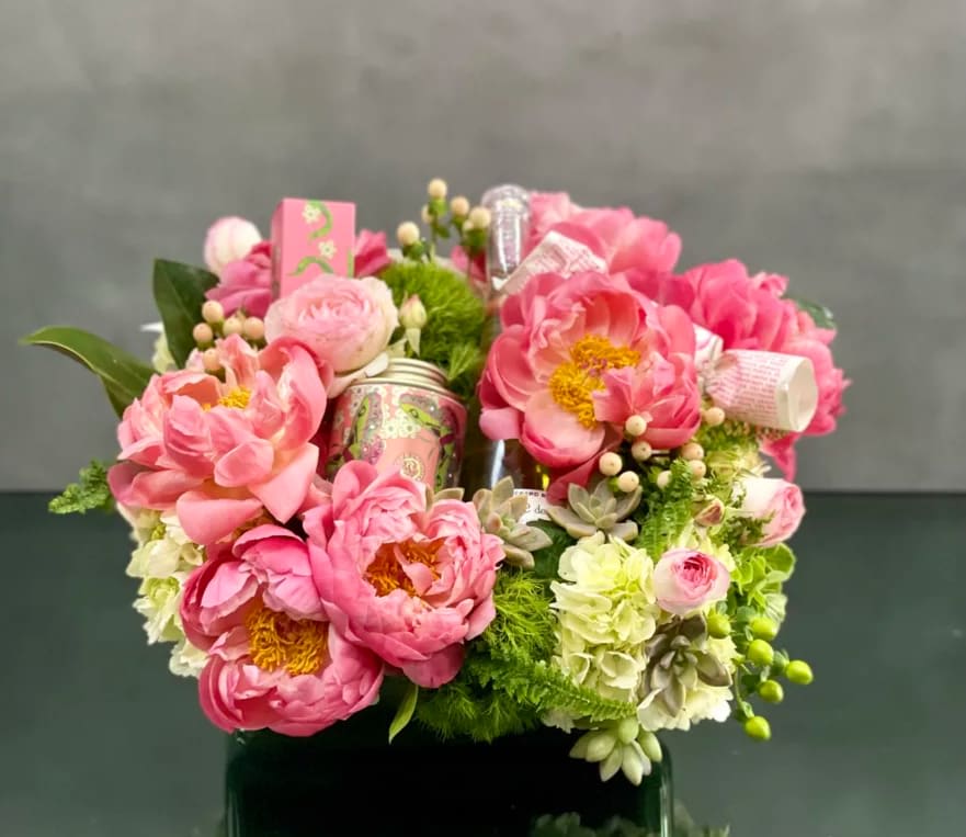 Peony and Gifts - Pasadena Florist - For same day Delivery - Presented in a 12-inch square box, approximately 15 inches wide and 7 inches tall, this elegant ensemble is ready to delight and enchant from the moment it arrives. With same-day delivery available, you can indulge yourself or surprise a loved one with this extraordinary gift set, ensuring that the luxury begins without delay. Whether it's a gesture of love, appreciation, or self-care, the Blooms and Bliss gift set promises to deliver moments of pure delight and relaxation that will be treasured long after the flowers have faded.  Immerse yourself or a cherished recipient in a realm of opulence and relaxation with our Blooms and Bliss gift set, meticulously crafted to transform ordinary moments into extraordinary indulgences.  At the core of this luxurious ensemble lies the breathtaking beauty of peonies, each bloom handpicked for its unrivaled elegance and freshness. These enchanting flowers, symbols of romance and grace, create a stunning visual display that captivates the senses and uplifts the spirit.  Enhancing the floral splendor is a bottle of fine white wine, carefully selected to elevate moments of relaxation and celebration. Delight in the delicate flavors as you unwind and embrace the luxury of the present moment.  But the indulgence doesn't end there. Our Blooms and Bliss gift set also features rose-infused bath salts, expertly crafted to envelop you in a cloud of soothing fragrance and luxurious hydration. Let the worries of the day dissolve as you immerse yourself in a bath infused with the delicate scent of roses, transporting you to a state of pure serenity.  To complete this sensory experience, we've included a decadent cream, enriched with nourishing ingredients to pamper your skin and leave it feeling velvety soft, supple, and rejuvenated.
