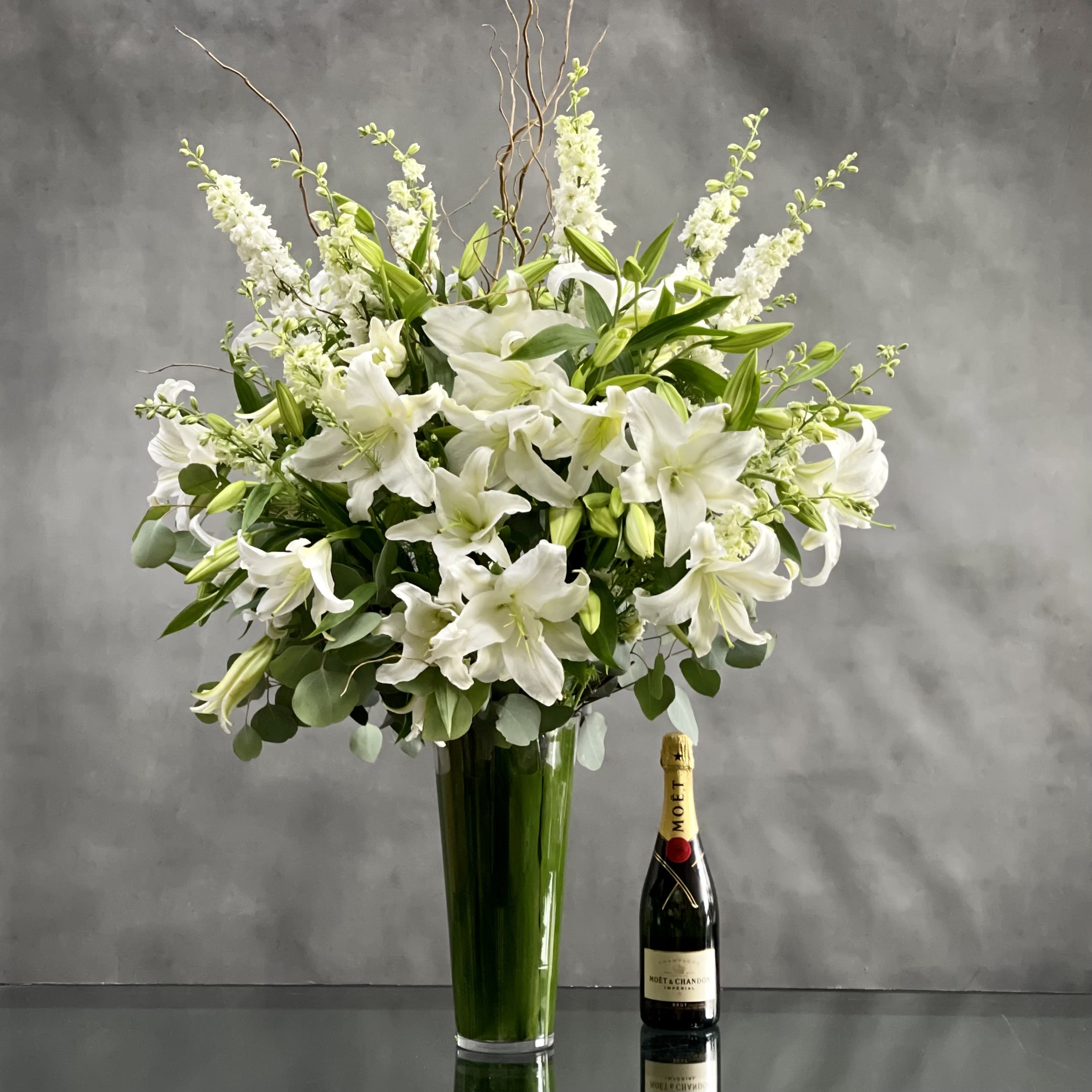 White Lily's Standing Tall - Pasadena Florist  - This Display of over 20 Stems of Crystal White Lily's accented with locally Grown Flowers and Greens is available for same day Delivery at Beverly Hills Florist. This Bouquet is placed in a leaf lined 14" Tall vase with an opening of 5"  and it is Approx. 45" Tall and 32 Wide.   As Shown Standard  Deluxe: 40 Stems  Premium: 50 Stems  