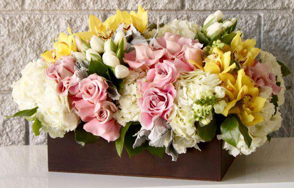Breath of Spring - Breathtakingly beautiful!.... A specialty piece like no other.  Dozens of Spring blooms including stunning Roses, lovely Hydrangeas, graceful Tulips, and delicate Sweet Peas abundantly fill this wood box with luscious pastels and billows of gorgeous flowers in an artistic design. A rich and elegant design that will be welcomed with open arms.