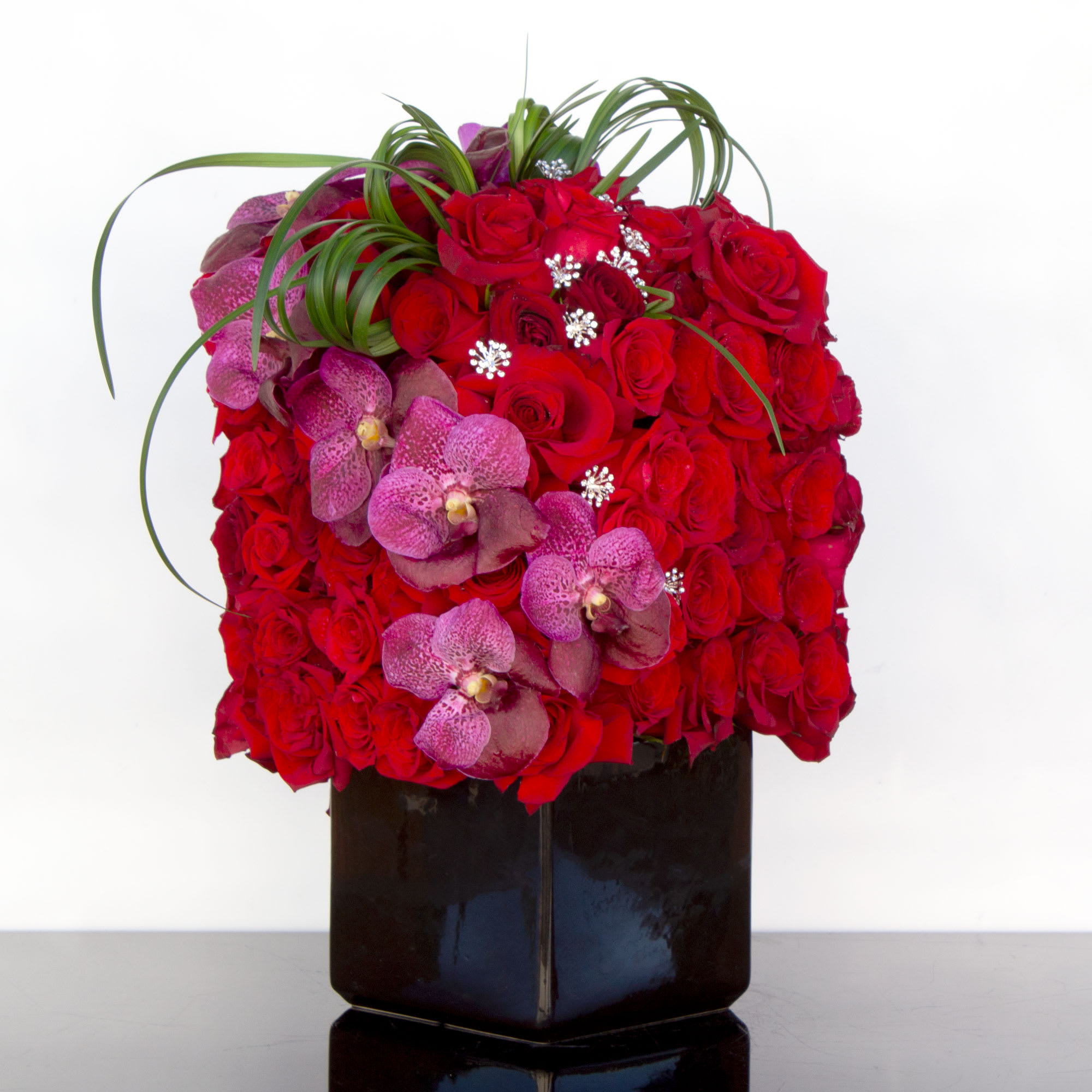 Roses and Orchids Towering Above - dgflkjdflkjd;lfkjasd;lfj;alfdjl; 100 roses and vanda orchids This stunning arrangement is perfect for any person and for any special occasion. One hundred red Roses accented by magenta Vanda Orchids speak for themselves as they symbolize love, care and compassion. This is the perfect classic-meets-modern floral arrangement. 