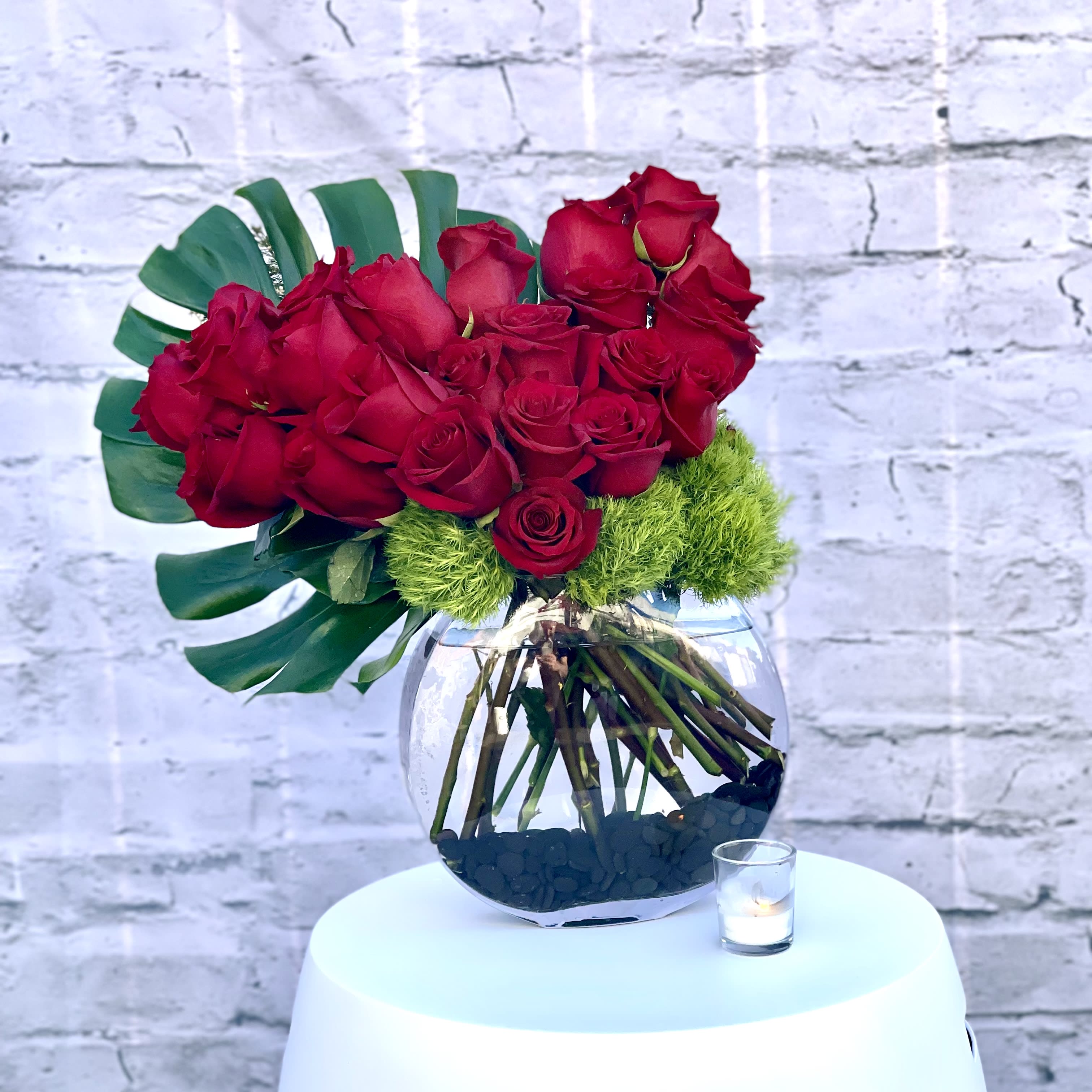 A Spoonful of Sugar - SOF - This splendid design features Red South American Roses in a moon vase. The greens compliment the deep red roses beautifully. This picture perfect floral gift will give beauty and meaning to the sentiments.  Standard : 2 dozen ( As Shown) Deluxe:  4 dozen 