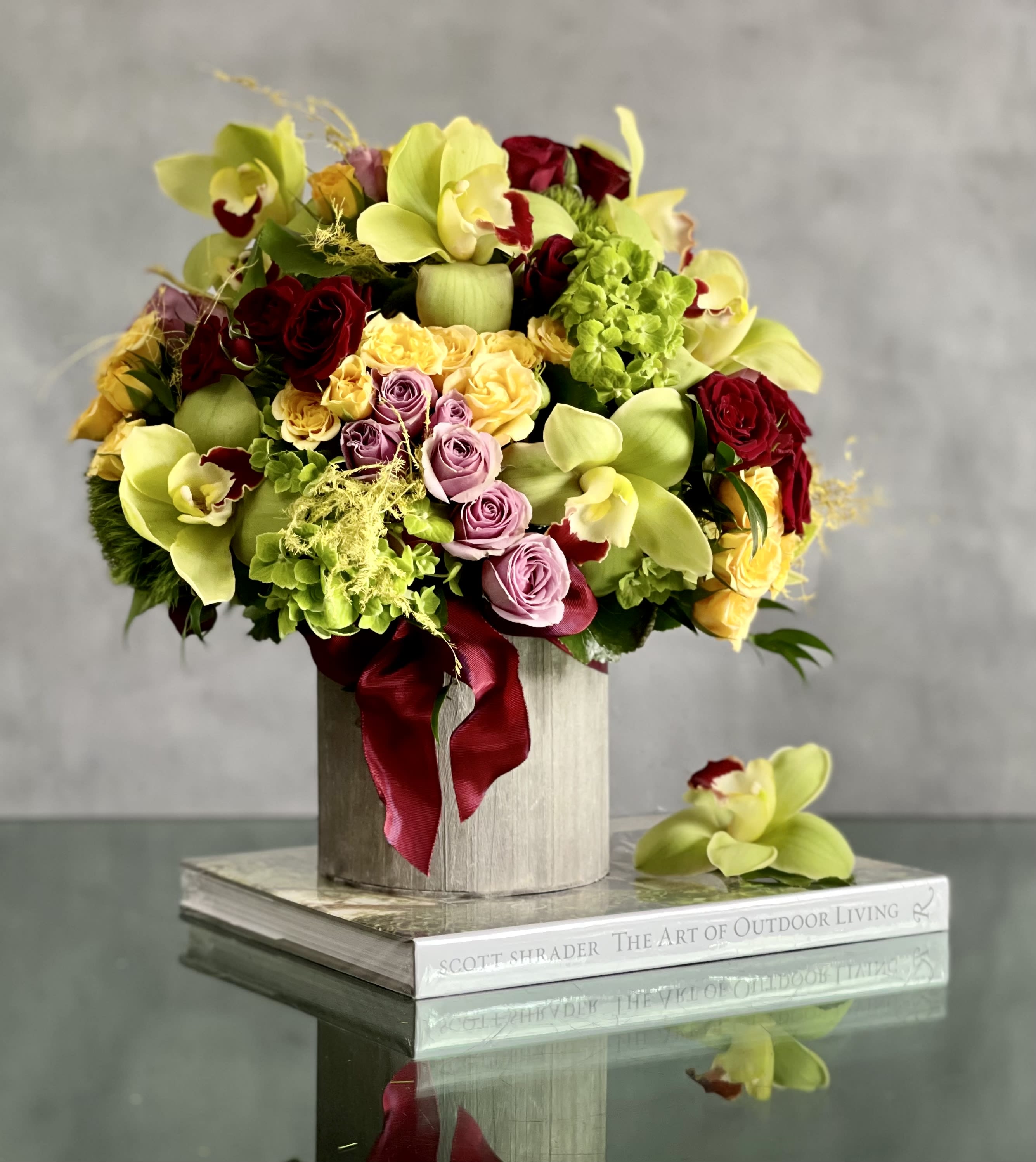 Eclipse of the Heart - An amazing rounded bouquet of 12 vibrant green cymbidium , red, yellow and lavender imported South American roses, and green Hydrangeas in a round rustic container . An ideal design for any occasion or celebration.  Dimensions: 16" TALL &amp; 14" WIDE