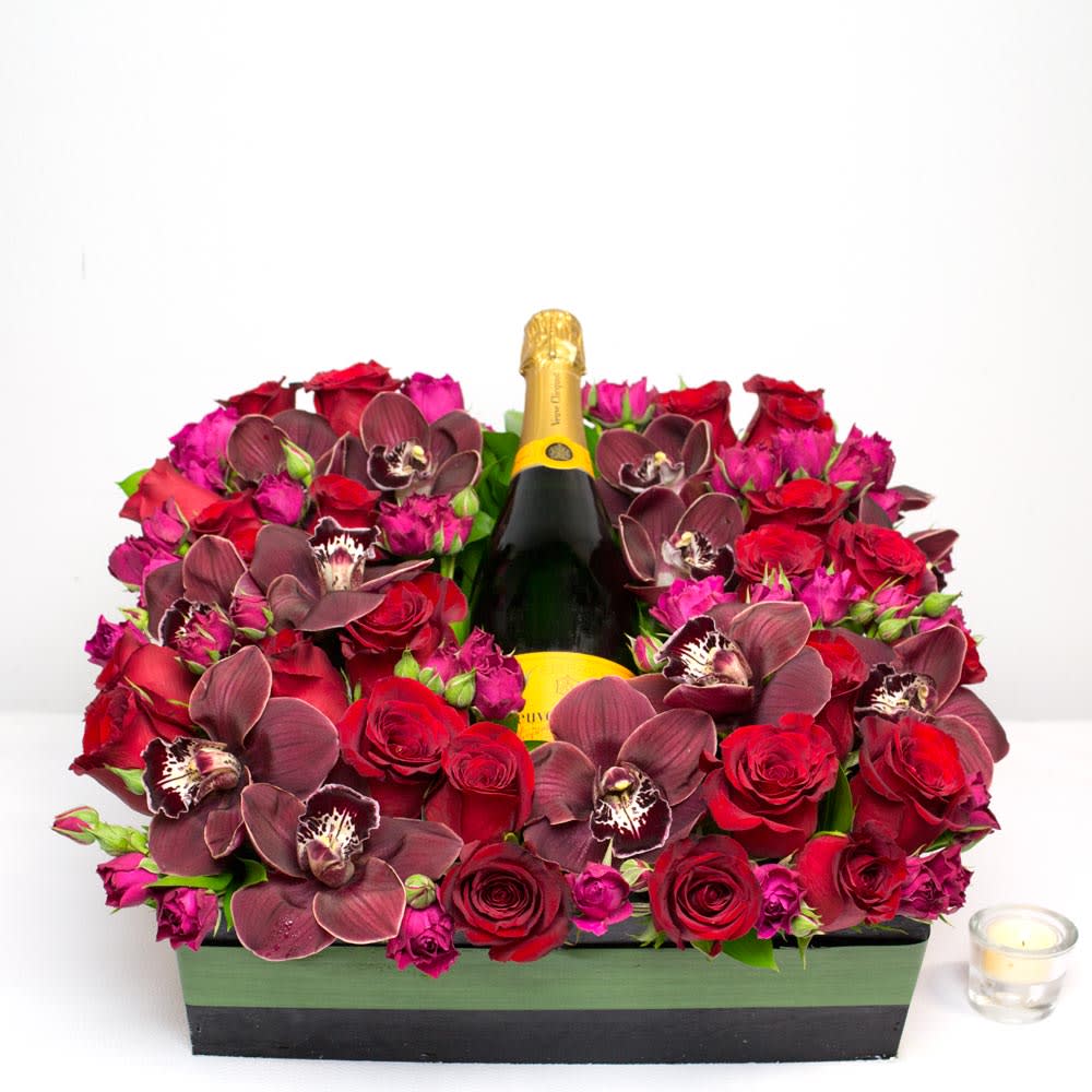 A Toast to You! - Sherman Oaks Florist - A bottle of good cheer surrounded by a mix of red and pink Roses and burgundy Orchids beautifully placed in a 20" square box.  Say congratulations, or send good wishes with this large and lovely gift of cheer in a bed of stunning florals. Recipient MUST be over age 21.    