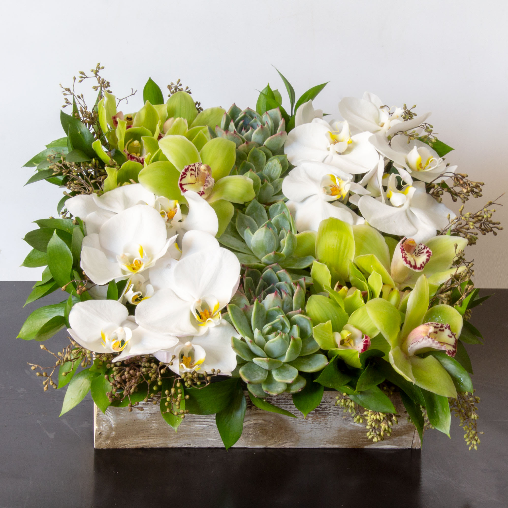 The Eternal Garden - Sherman Oaks Florist - The Eternal Garden is the perfect, practical gift. Show your special someone that your love is growing and vibrant. Our succulent garden comes with an array of lush desert beauties in a wood textured box flanked by Phalaenopsis and Cymbidium Orchids.  standard. 12 x 12 box   Deluxe. 24 X 24 Box