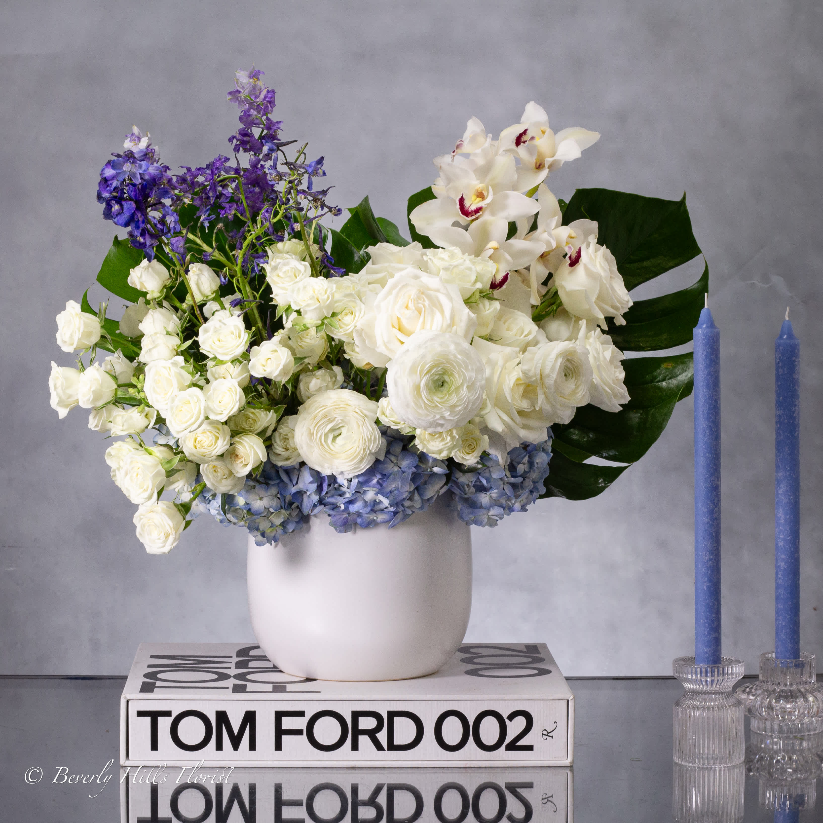 HEAVENLY HARMONY: BLUE AND WHITE BLOSSOMS - For a touch of elegance, consider our blue and white floral, meticulously handcrafted with fragrant white roses and interspersed with vibrant blue hydrangeas. This timeless symbol of unity and continuity is the perfect addition to your Passover table, radiating beauty and grace.  approx.: 14" Tall and wide 
