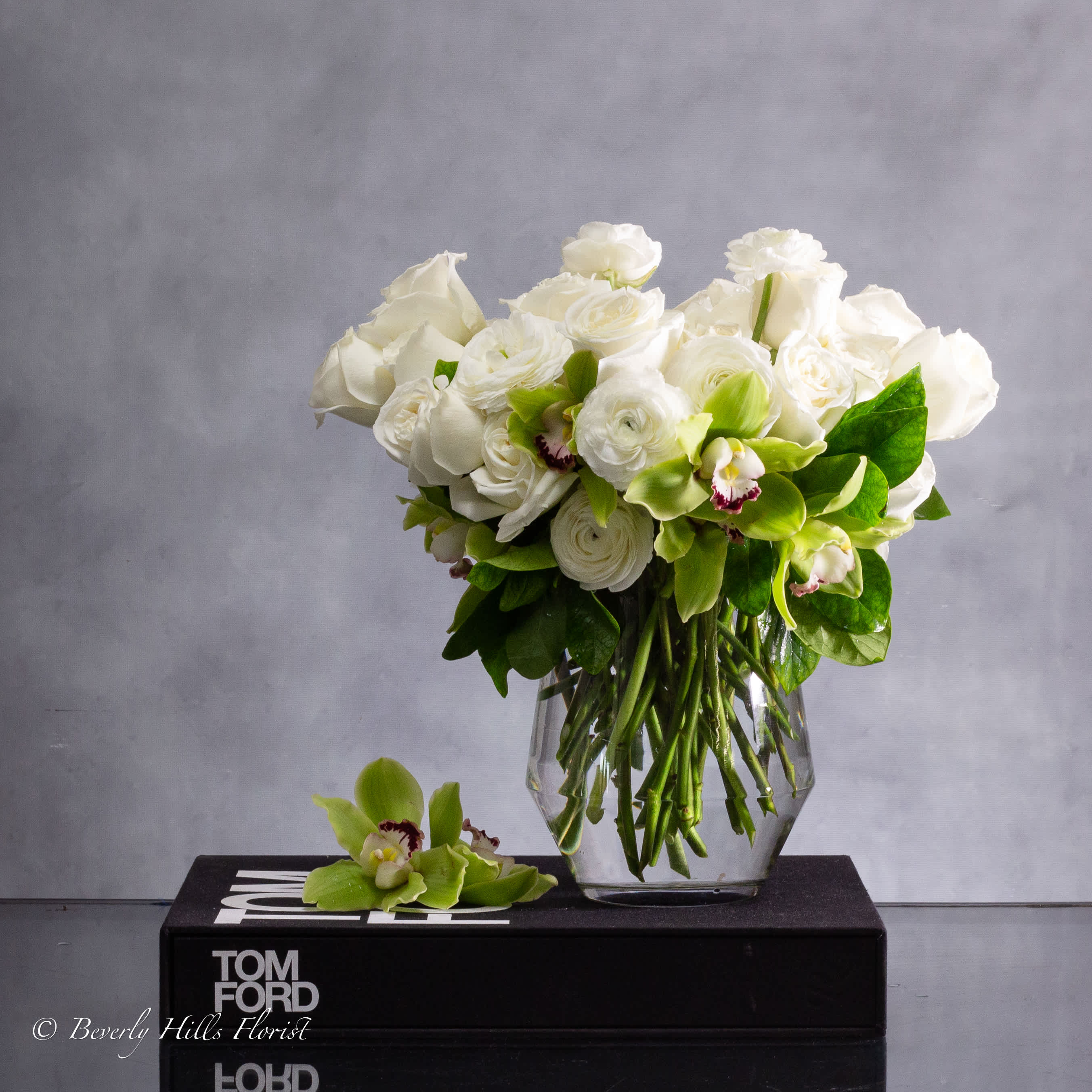 Playa - Embrace timeless elegance with our Green and White Classic Look floral arrangement. This sophisticated ensemble combines the crisp purity of white roses with the lush vibrancy of green orchids, creating a stunning display that exudes grace and refinement.    approx. 15" round&nbsp;  Each delicate petal is carefully selected and arranged to perfection, highlighting the natural beauty of these exquisite blooms. The pristine white roses symbolize purity and innocence, while the verdant green orchids represent vitality and renewal, making this arrangement a perfect choice for any occasion.  Whether you're celebrating a milestone moment or simply expressing your admiration, our Green and White Classic Look arrangement is sure to leave a lasting impression. Elevate your space with its understated elegance and let its timeless beauty brighten your day.  Available for same-day delivery in Beverly Hills, Los Angeles, and nearby cities, this arrangement is a beautiful way to convey your sentiments with style and sophistication. Order now and bring a touch of classic charm to any setting.