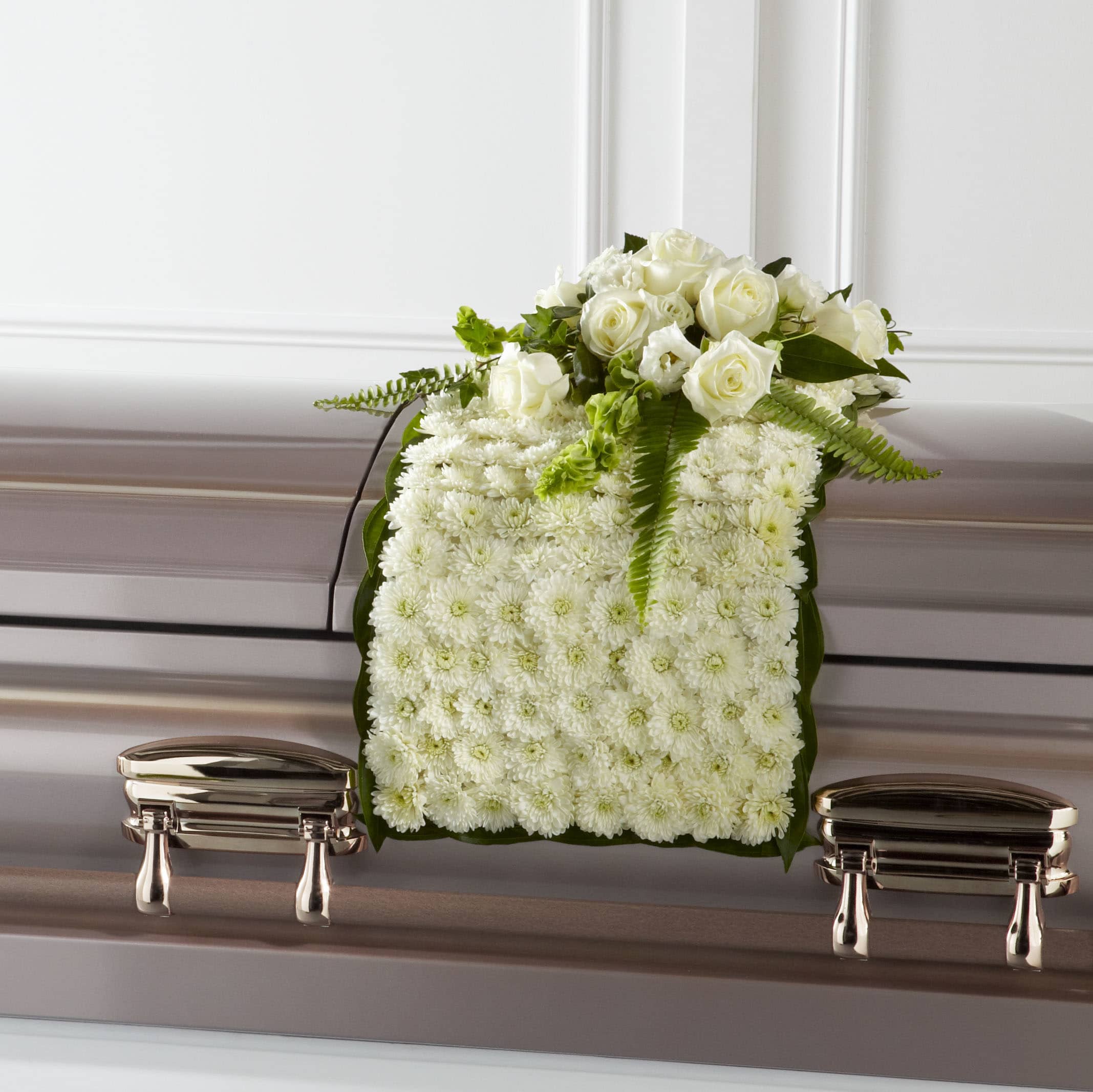 White floral casket spray with roses and chrysanthemums