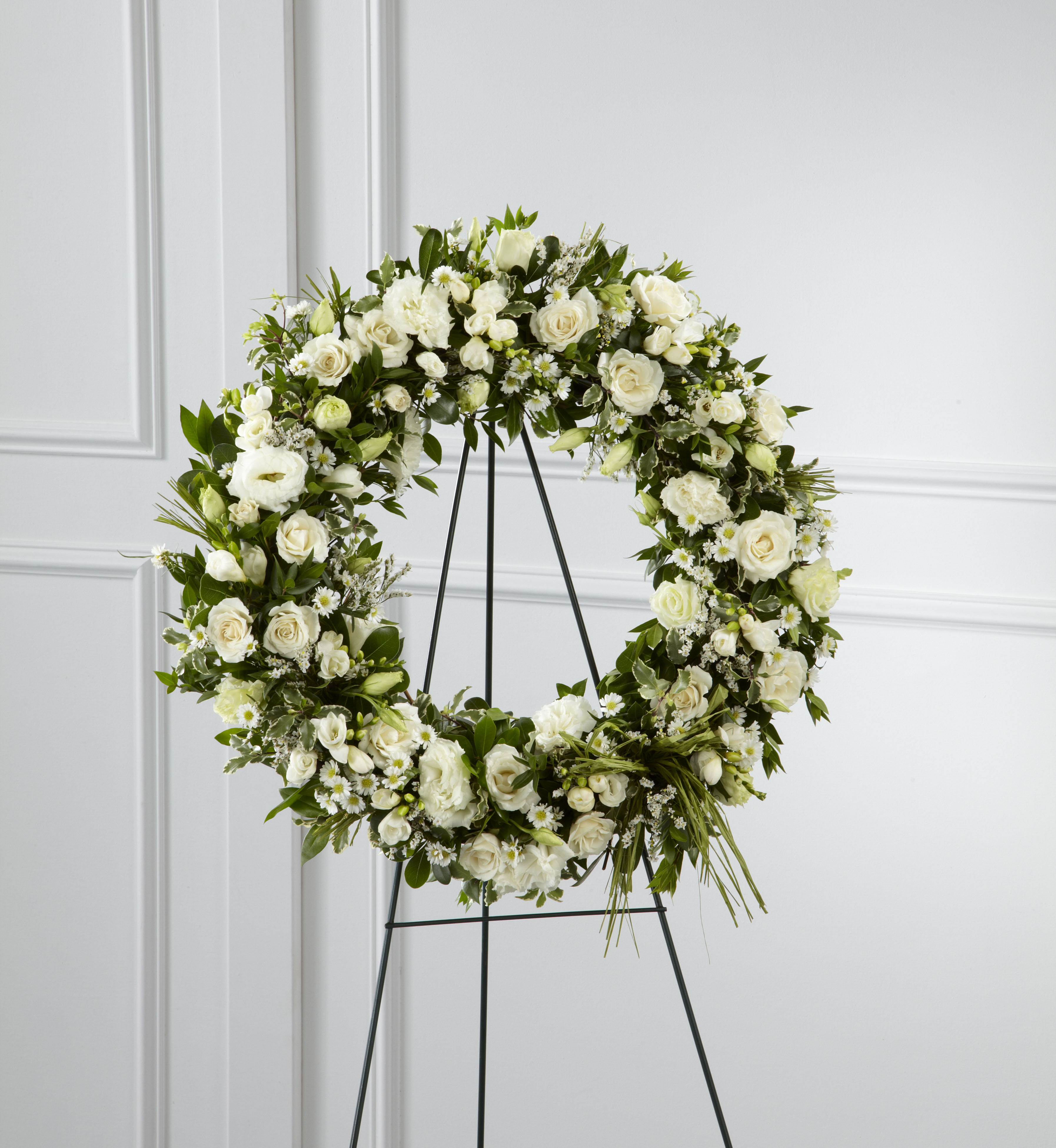 White floral wreath on a black stand
