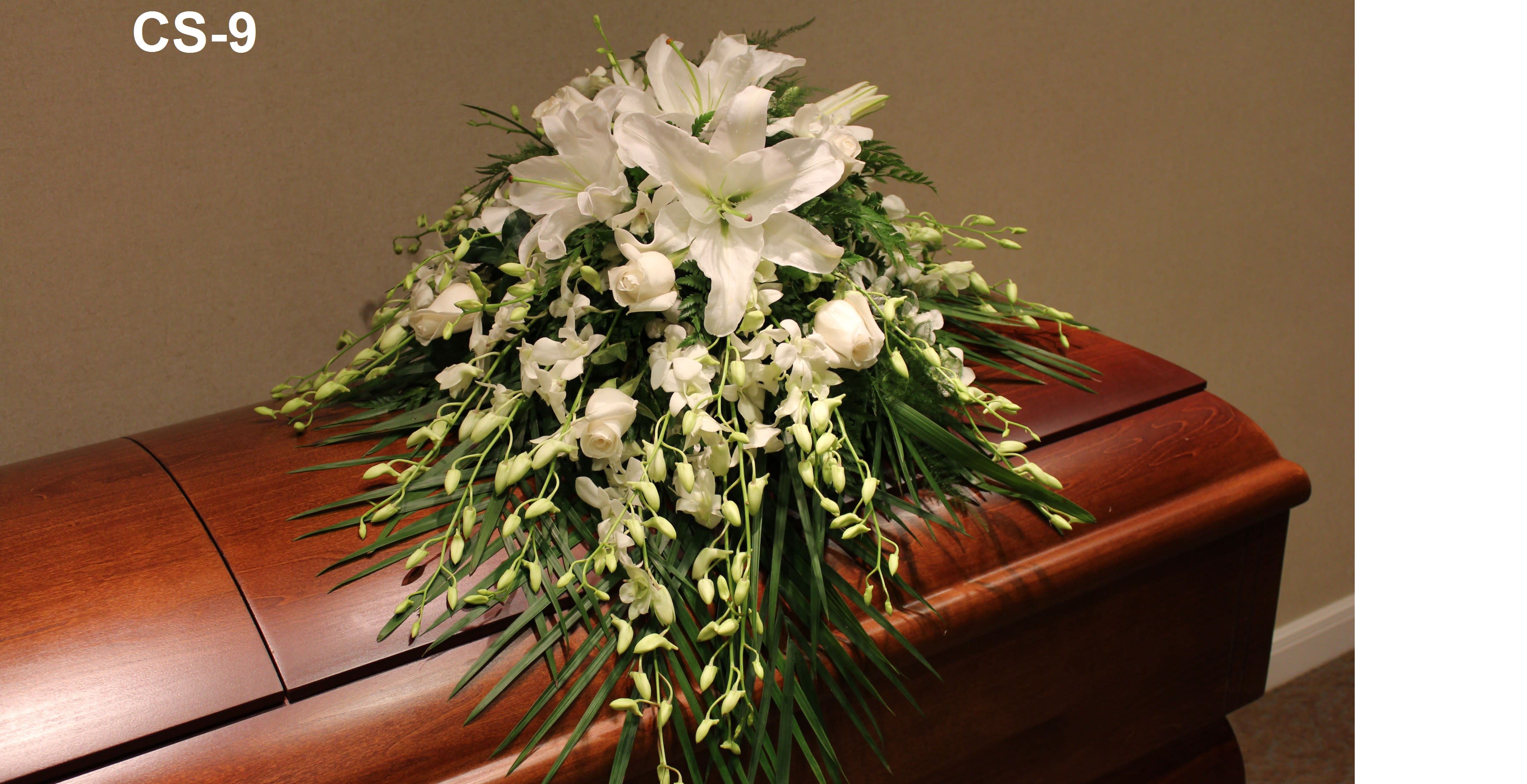 White floral spray on a wooden casket