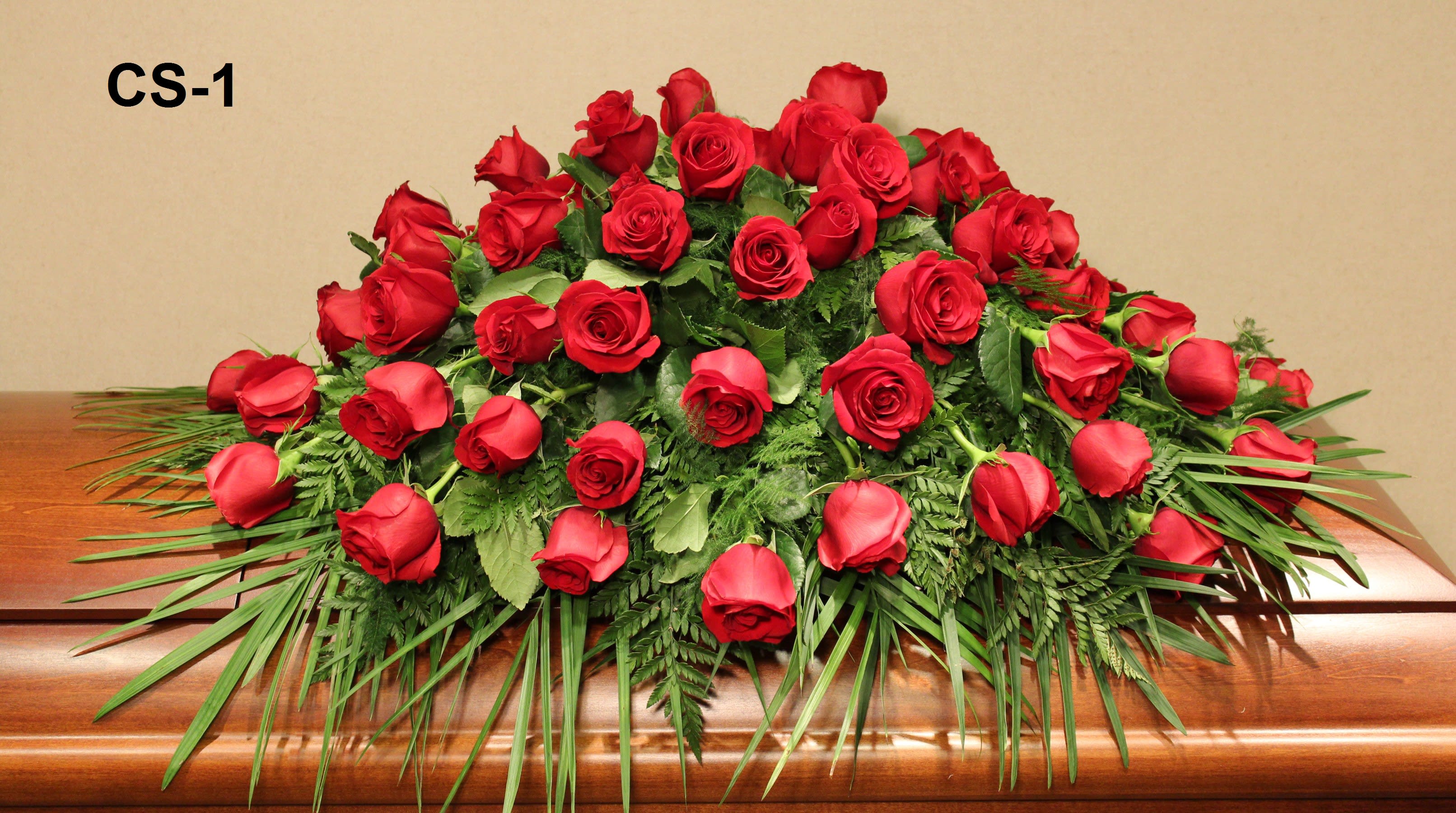 Casket spray of red roses with greenery