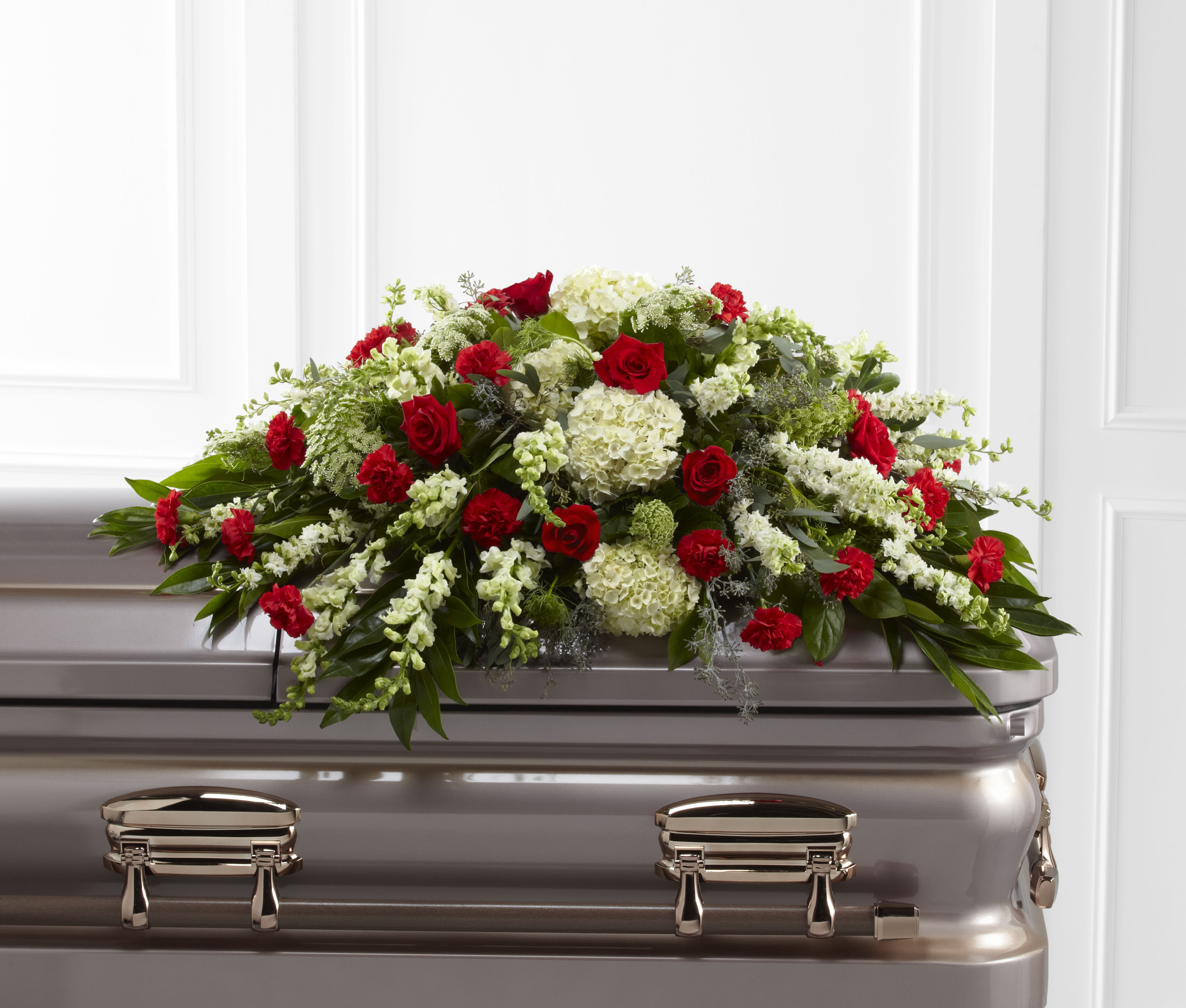 Red and white floral spray on a silver casket