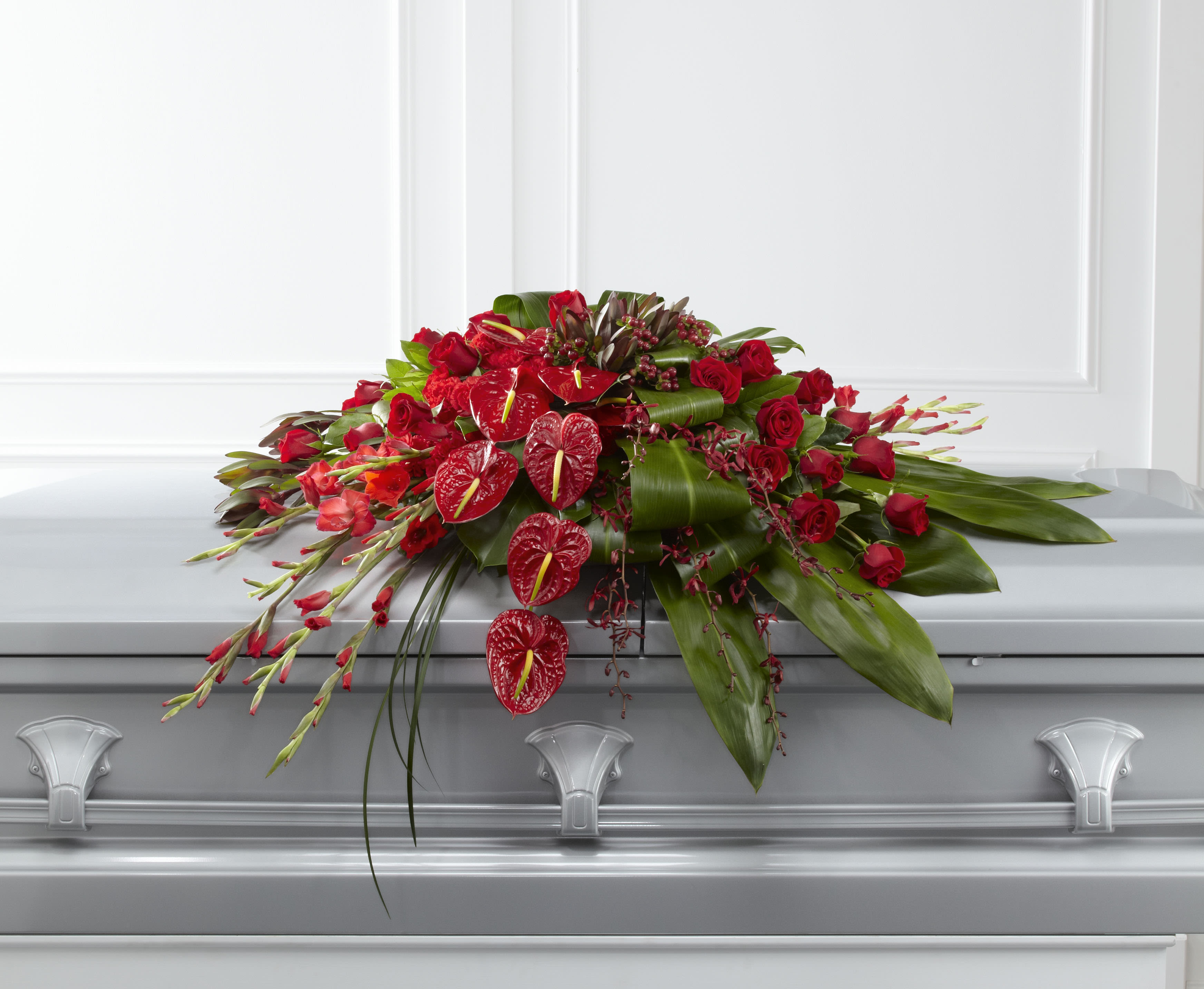 Red floral casket spray with roses and anthuriums