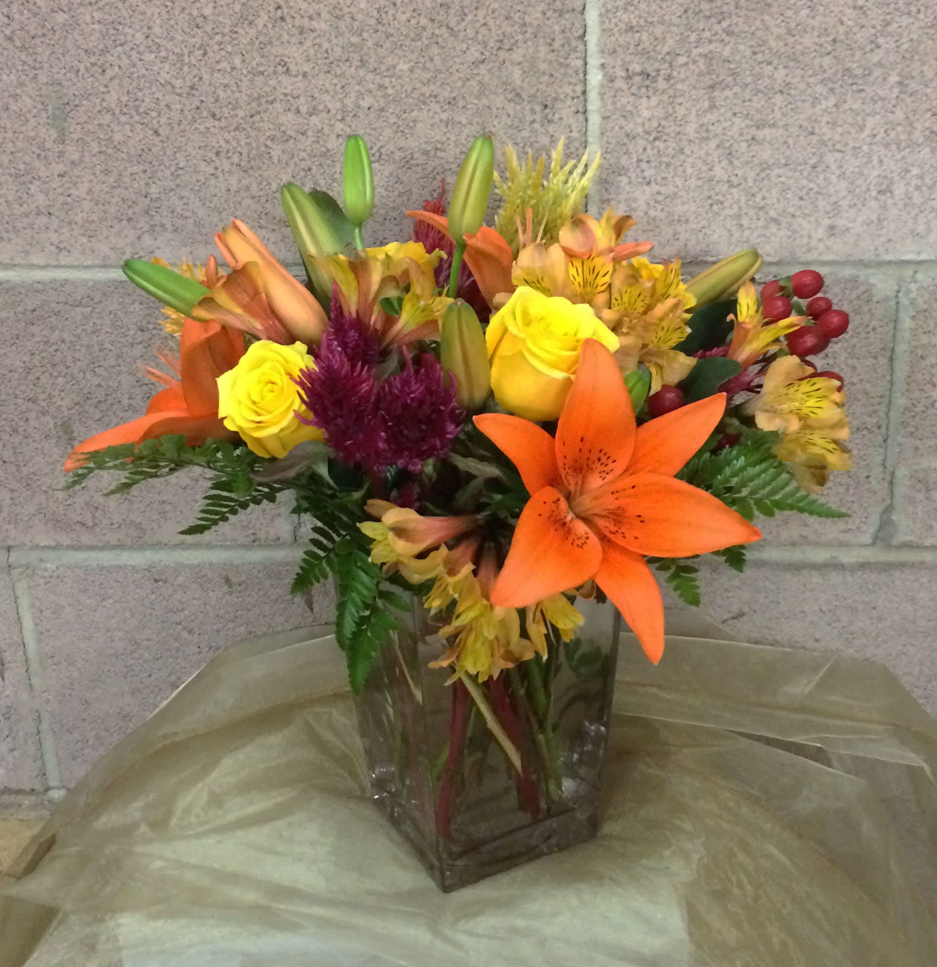 Mixed bouquet of lilies, roses, and alstroemeria in a glass vase