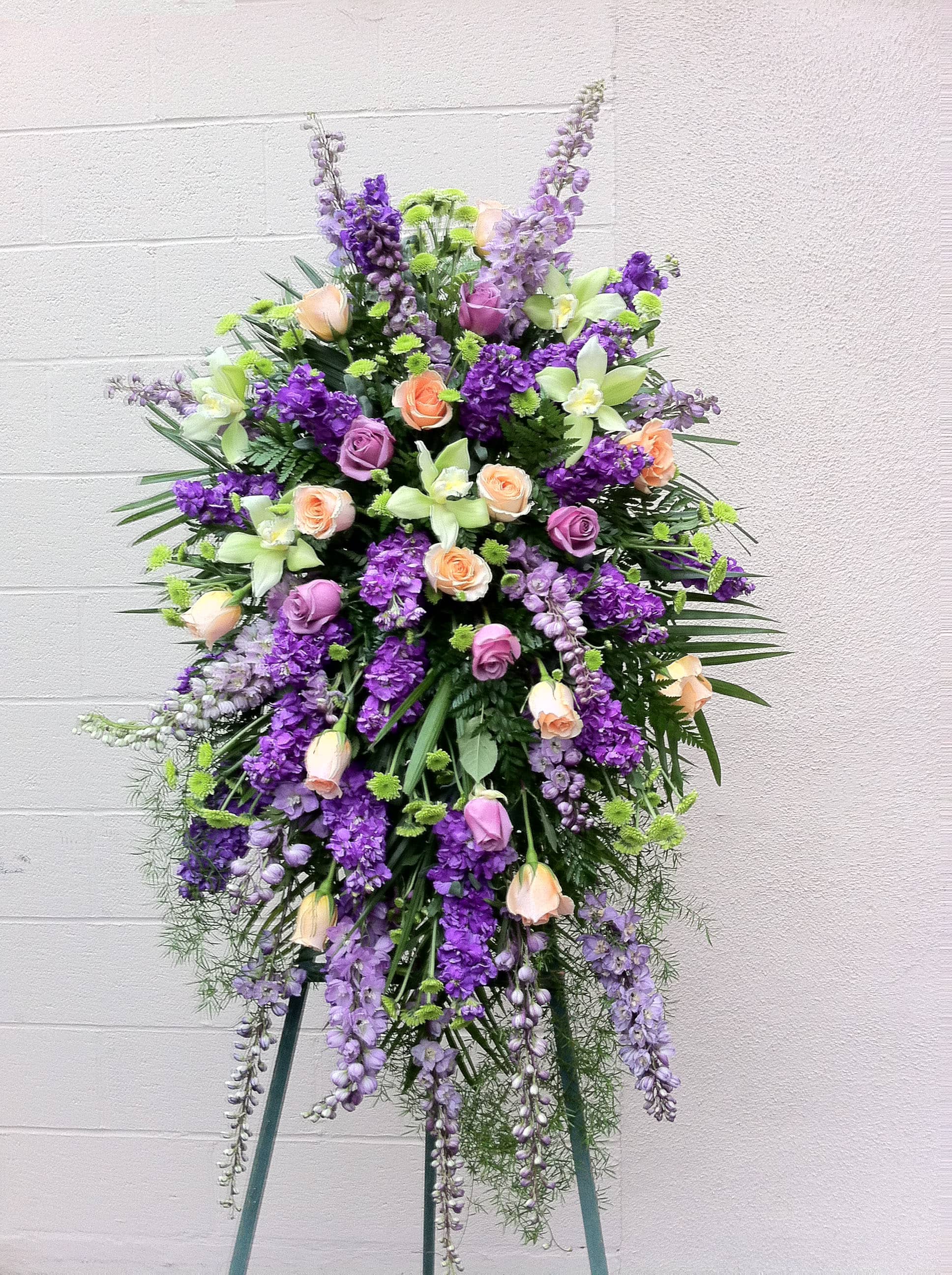 Tall standing floral spray with purple and peach roses