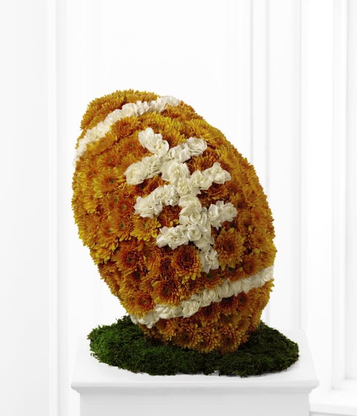 Floral standing spray with orange and white flowers on a green base
