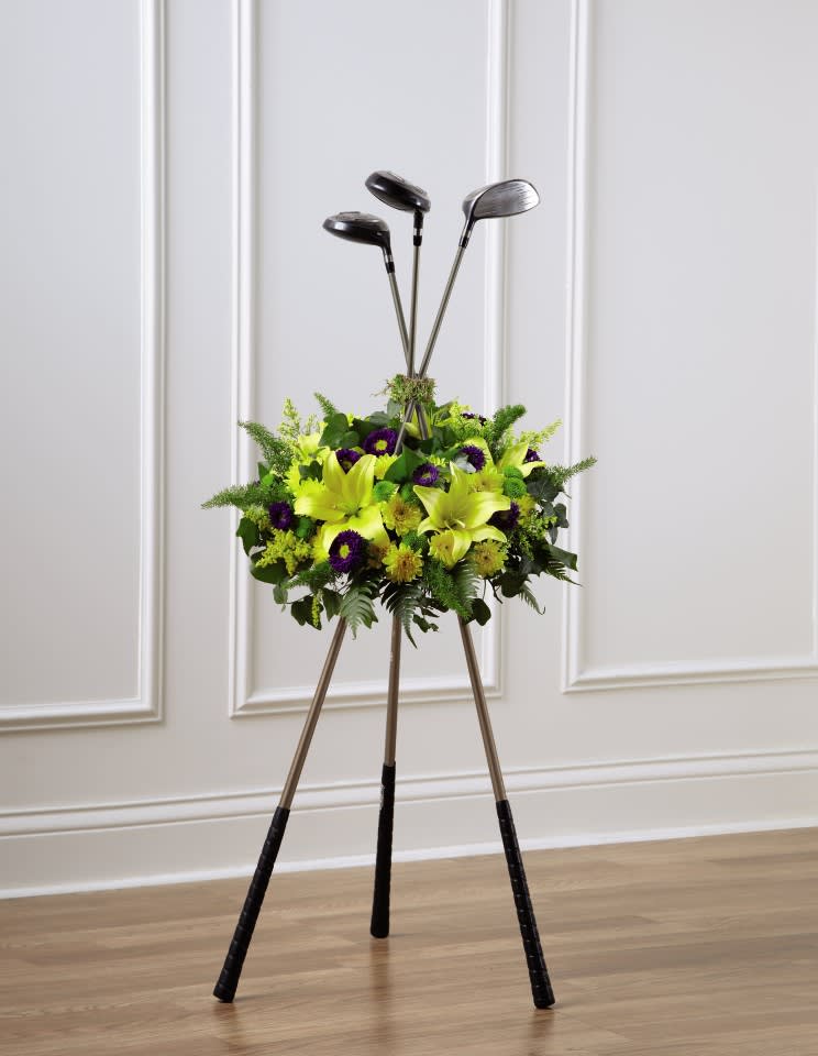 Golf clubs arranged in a floral display with yellow and purple flowers