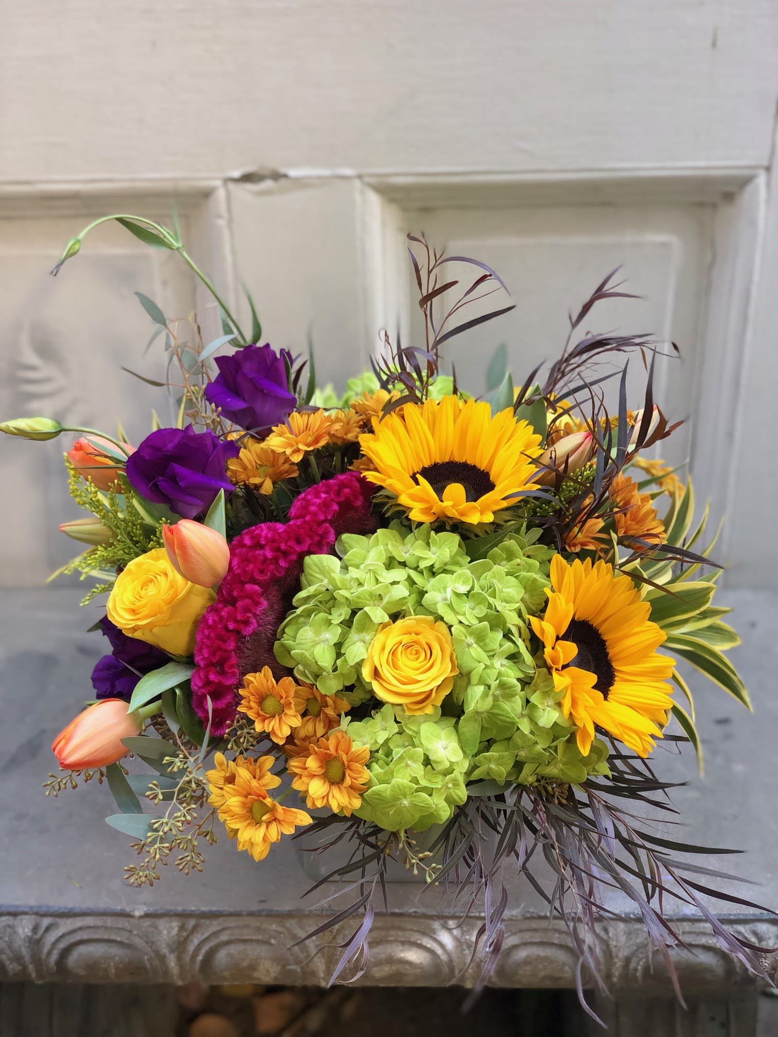 Bright mixed bouquet with sunflowers, roses, and purple blooms