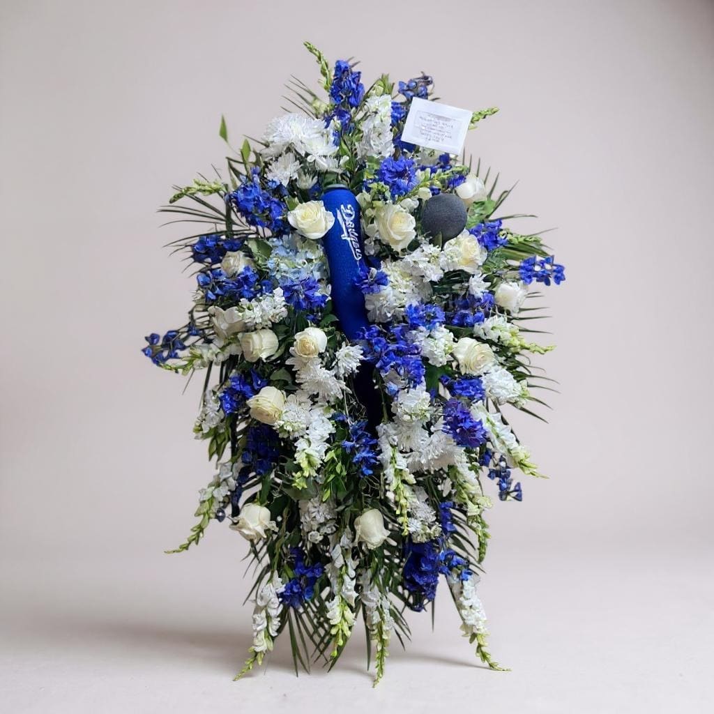 Blue and white floral standing spray with a ribbon in the center