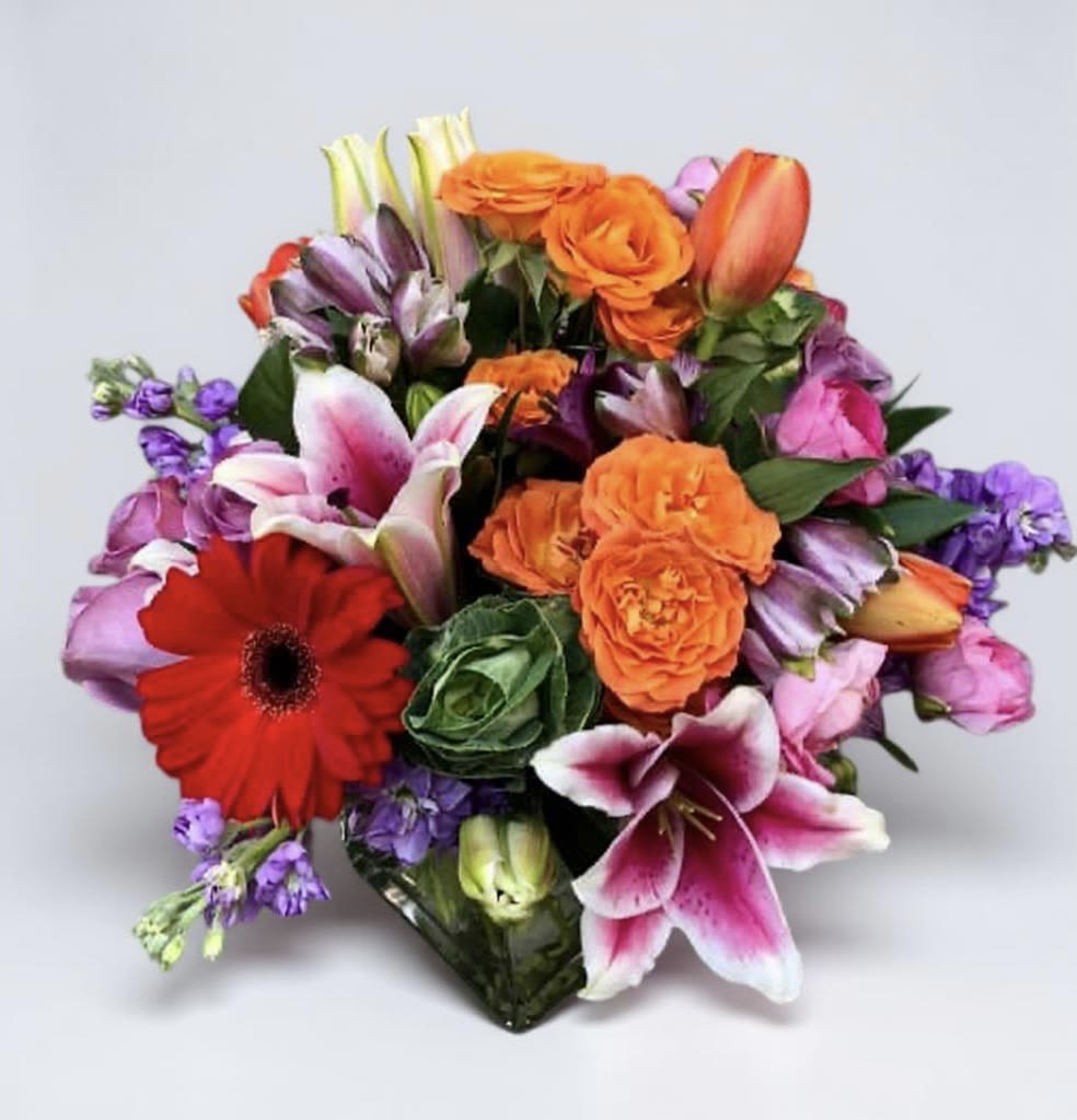 Mixed bouquet with orange roses, lilies, and a red gerbera daisy