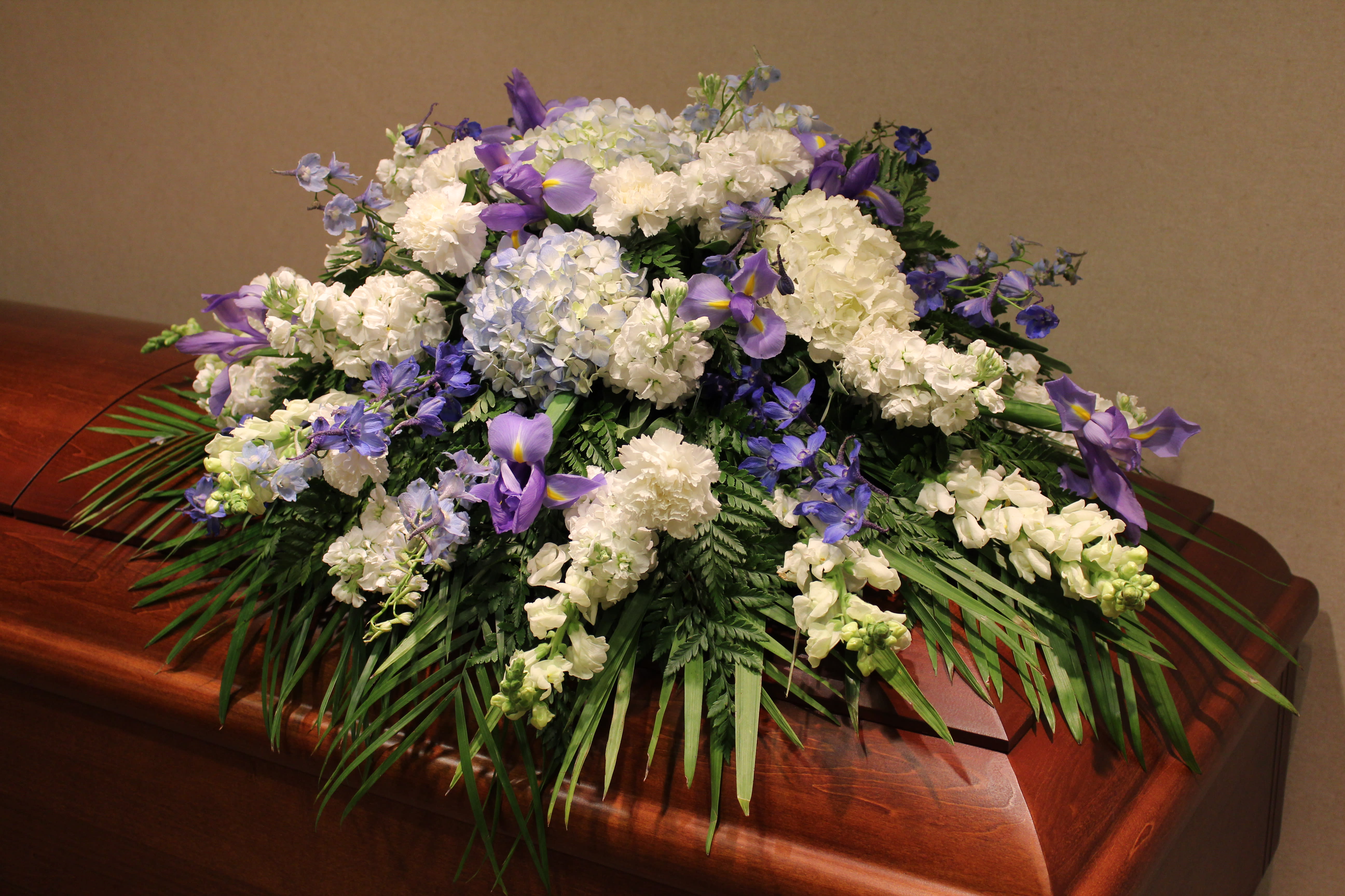 White and purple funeral spray on a casket