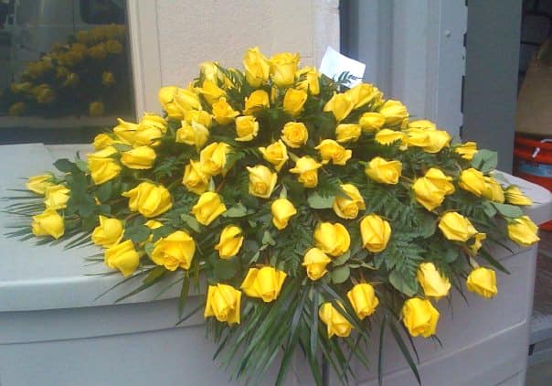 Large arrangement of yellow roses on a casket