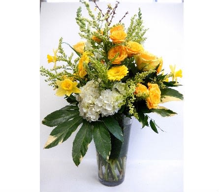 Yellow flowers and white hydrangea in a clear glass vase