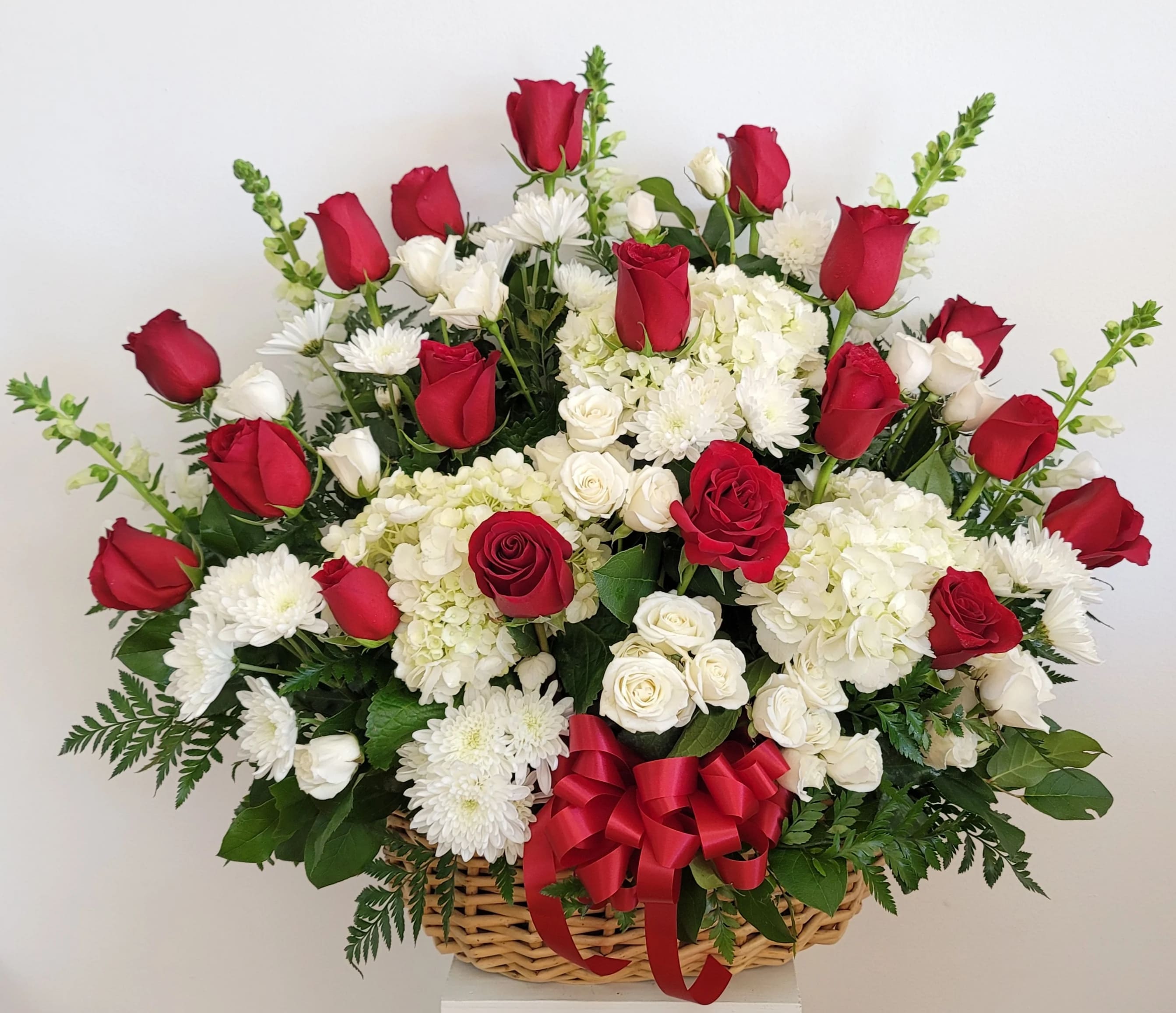 Basket arrangement of red and white roses with white chrysanthemums