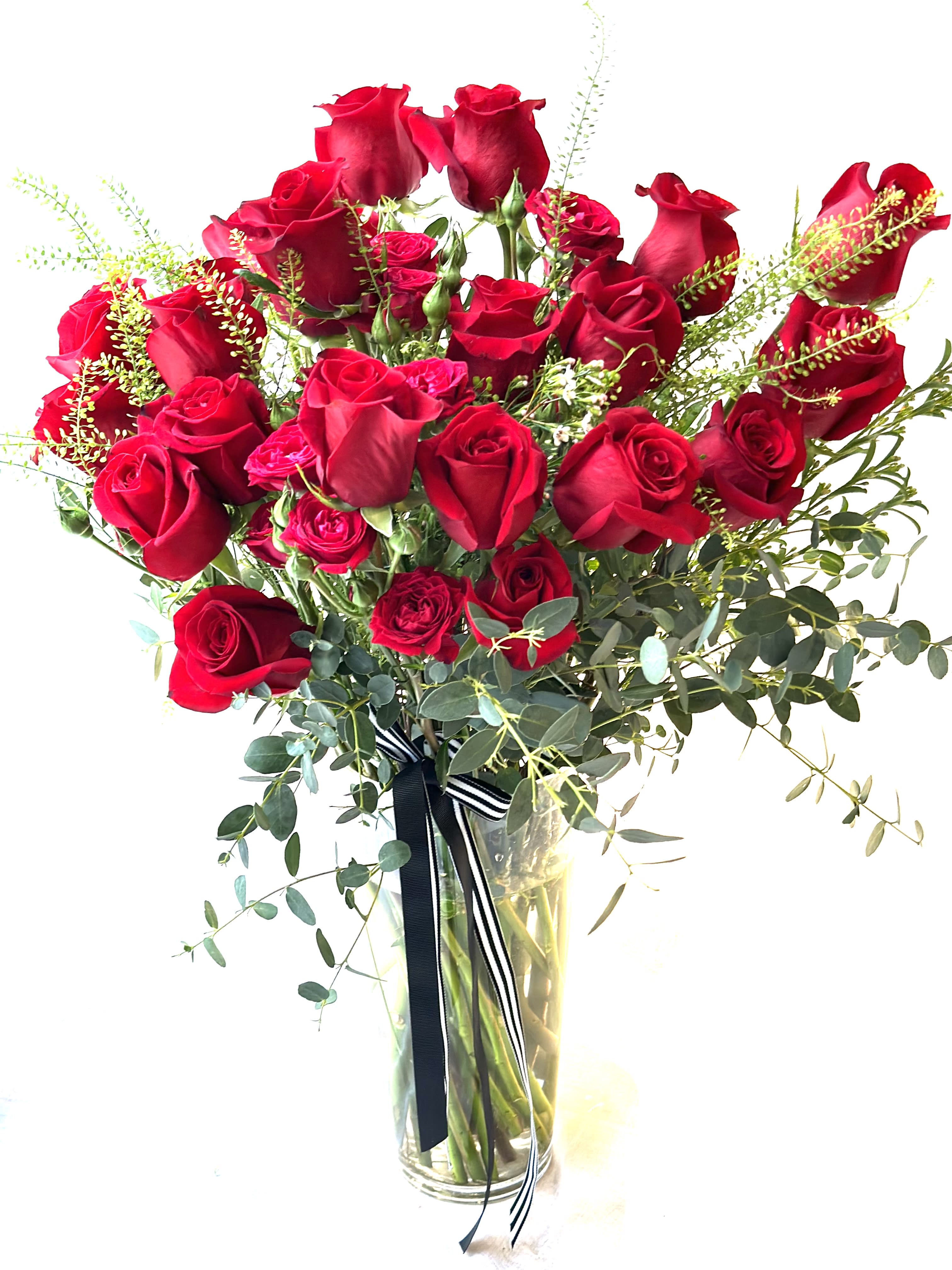 Bouquet of red roses in a clear glass vase with ribbon