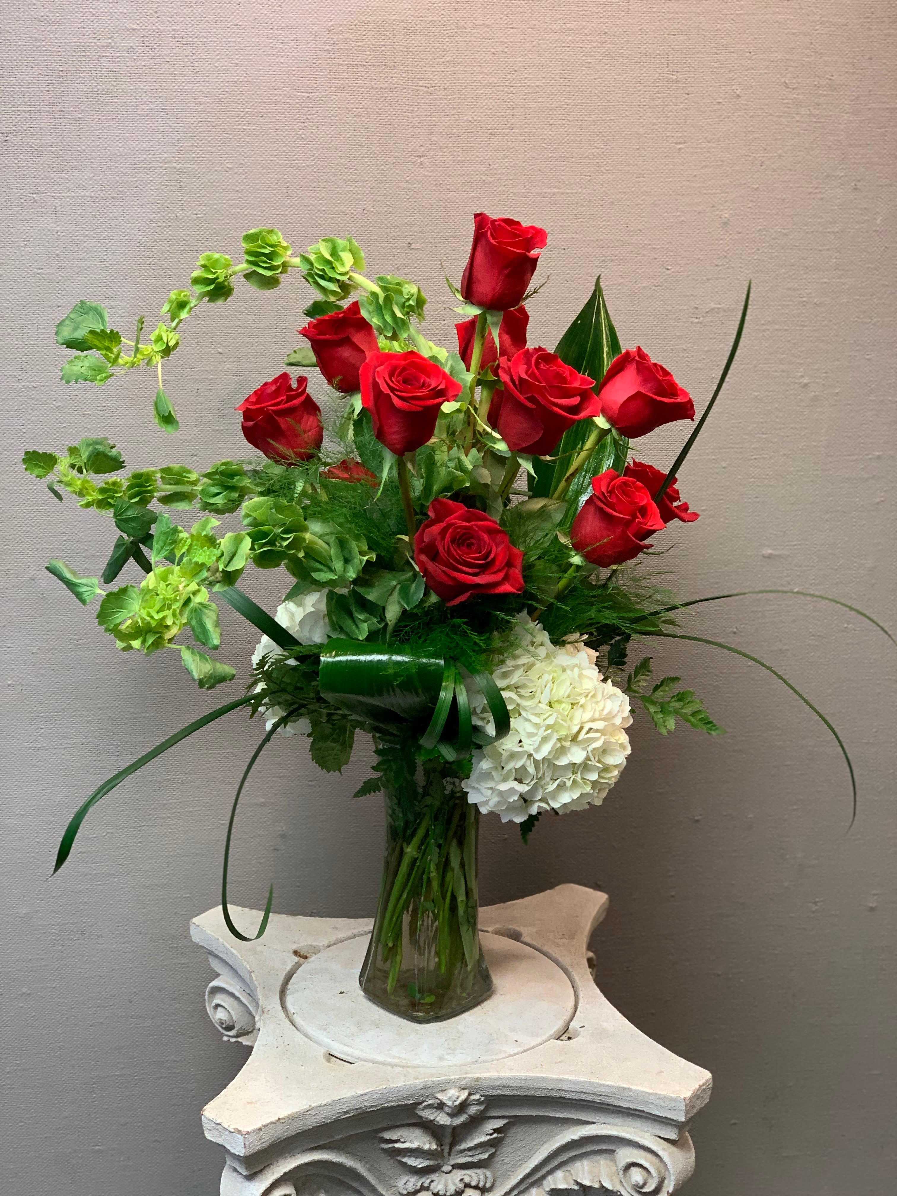 Red roses and white hydrangeas in a clear glass vase