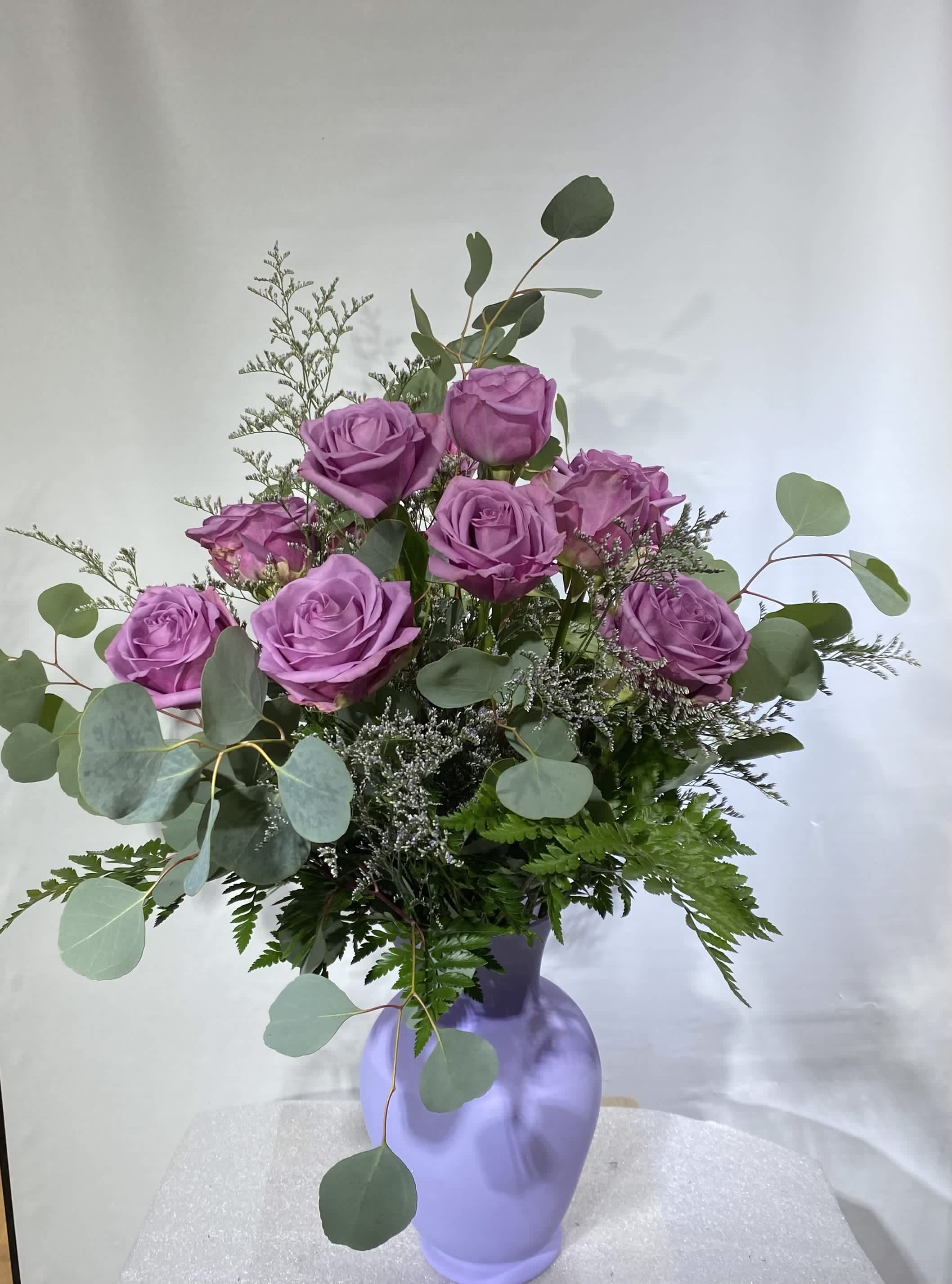 Dozen Long Stemmed Lavender Roses by BloomNation™ - This arrangement is the perfect "pick me up" to brighten someone's day. Dozen Long Stemmed Lavender Roses by BloomNation™ is the perfect gift for a birthday, get well, just because, and thank you.    Arrangement Details: 12 Long Stemmed Lavender Roses and Assorted Greenery APPROXIMATE DIMENSIONS: 25" H X 18" W