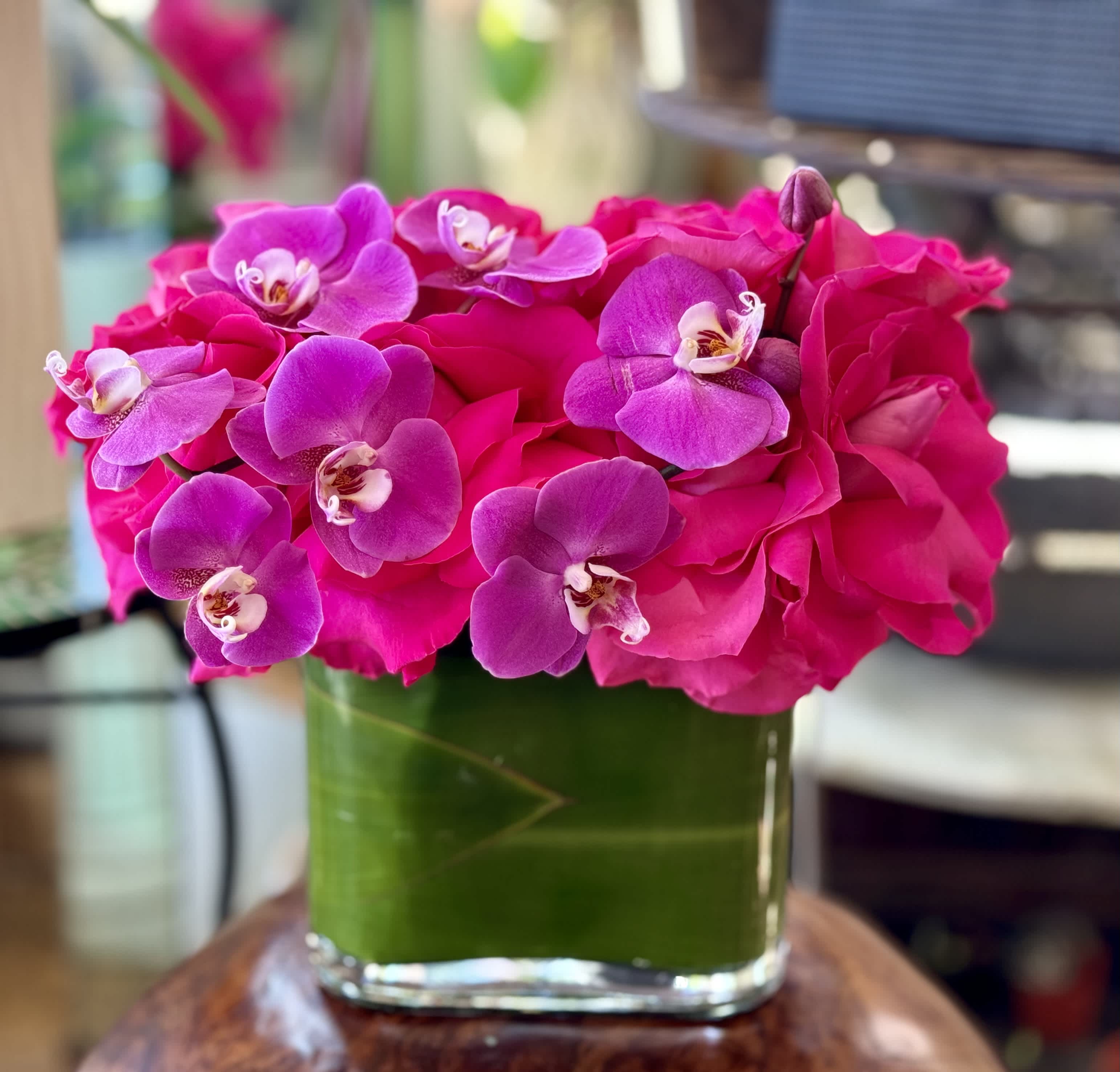 Pink roses and purple orchids in a glass vase