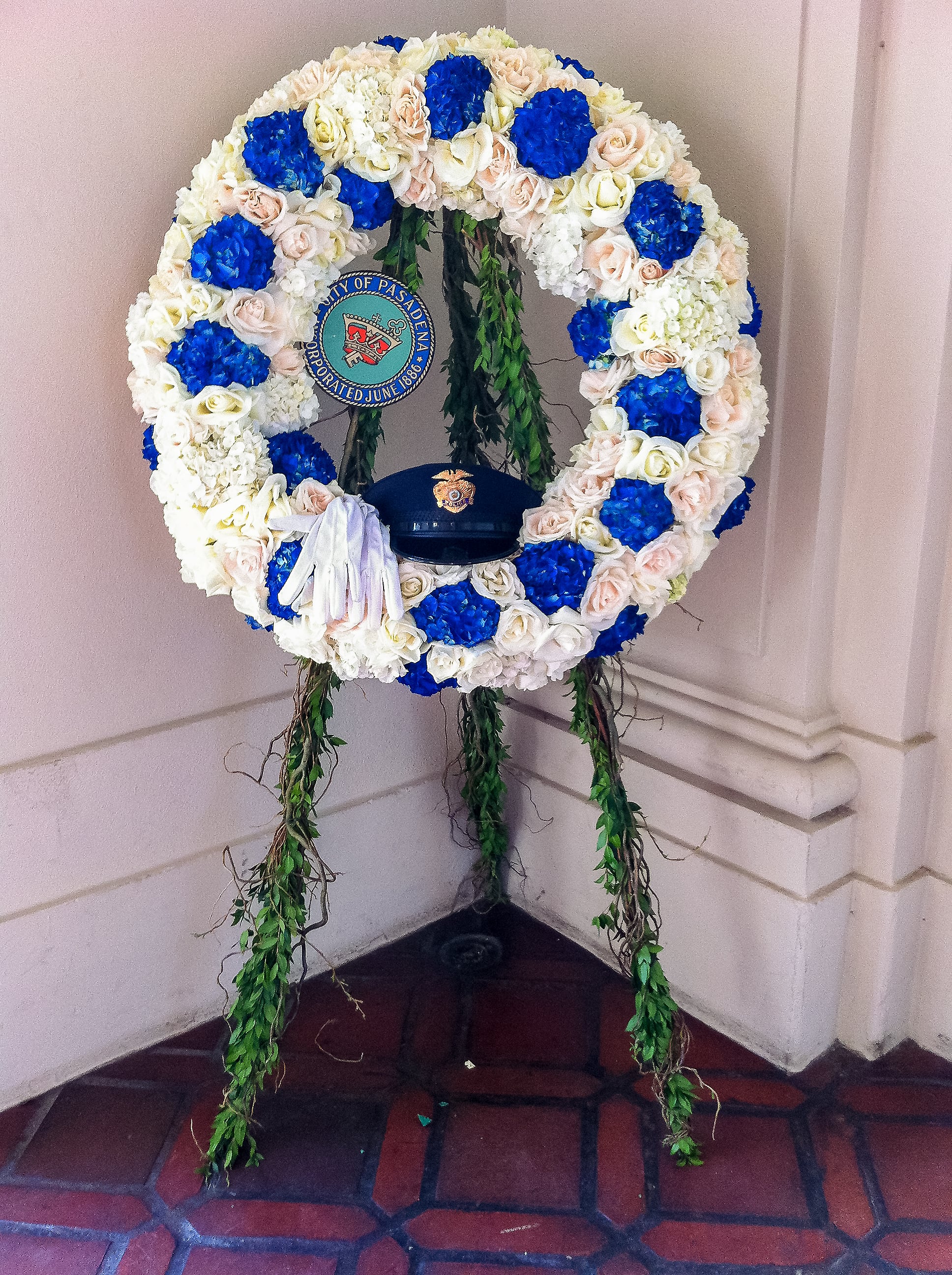 Large floral wreath with blue, white, and blush flowers on a stand