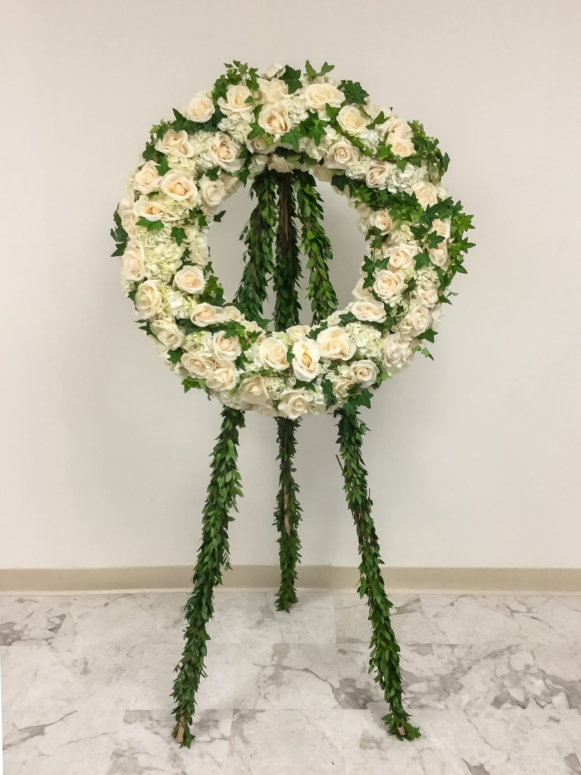 White rose funeral wreath on a standing easel