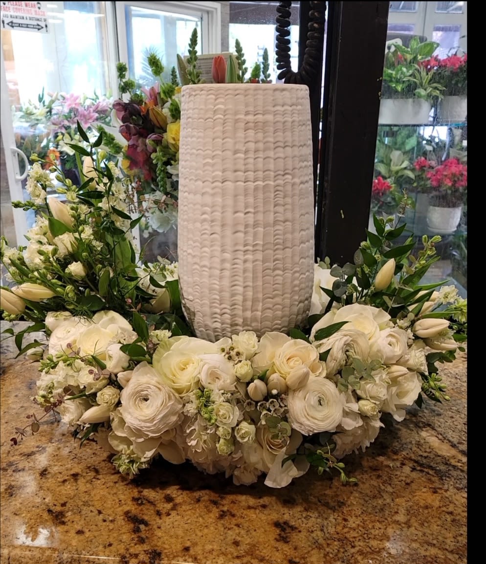 White floral wreath around a tall textured vase