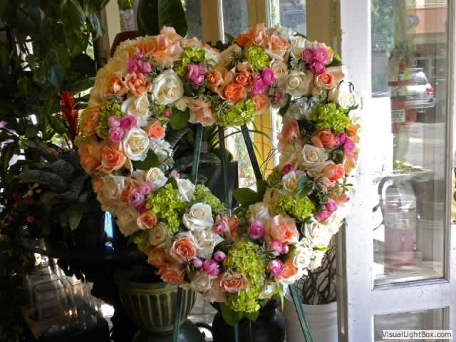 Heart-shaped floral wreath of roses and hydrangeas on an easel