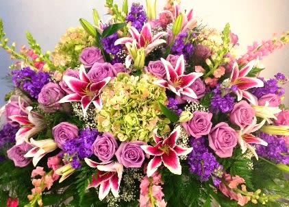 Large bouquet of purple roses and pink lilies with mixed blooms