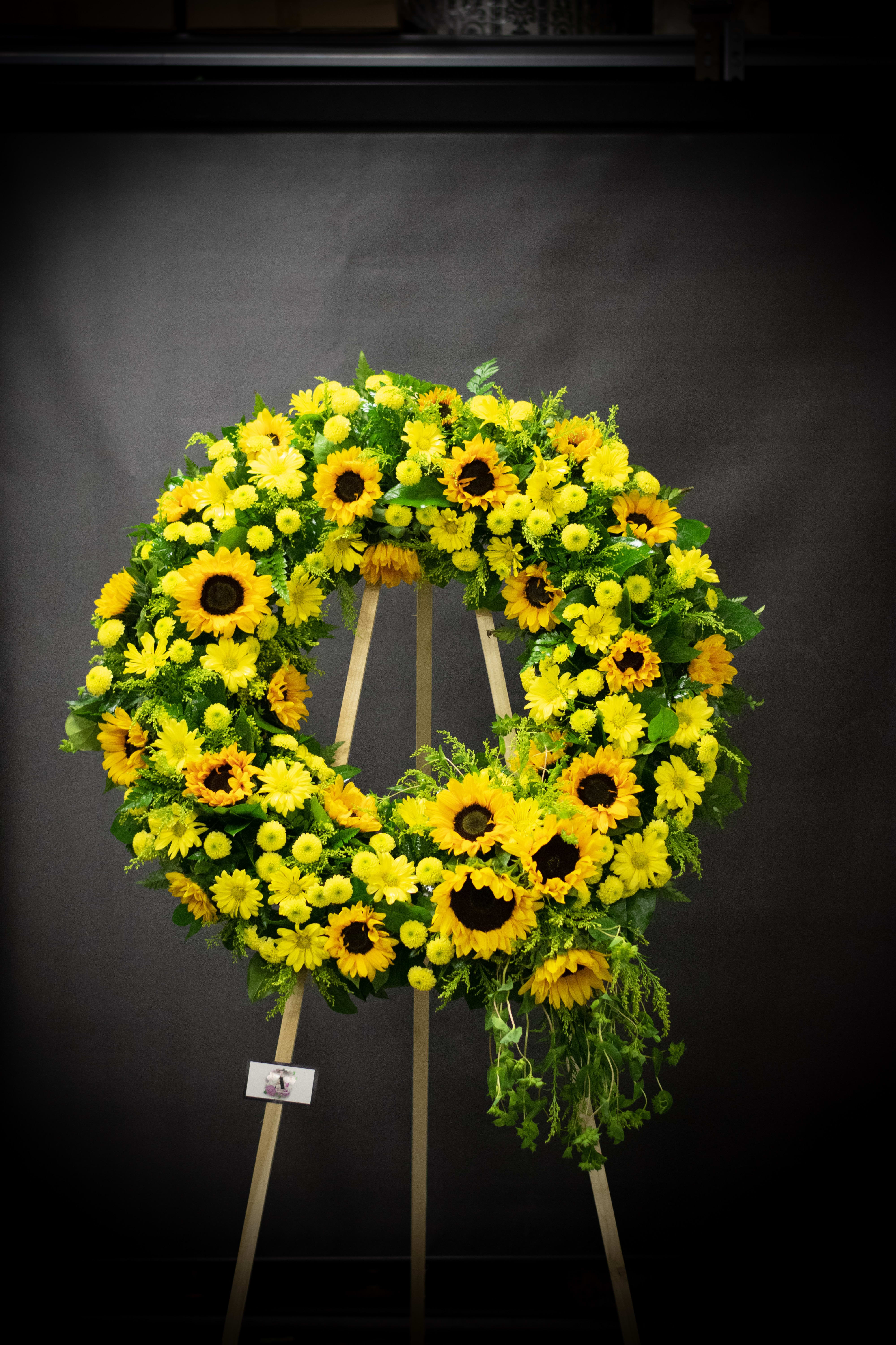 Large yellow floral wreath on a wooden easel