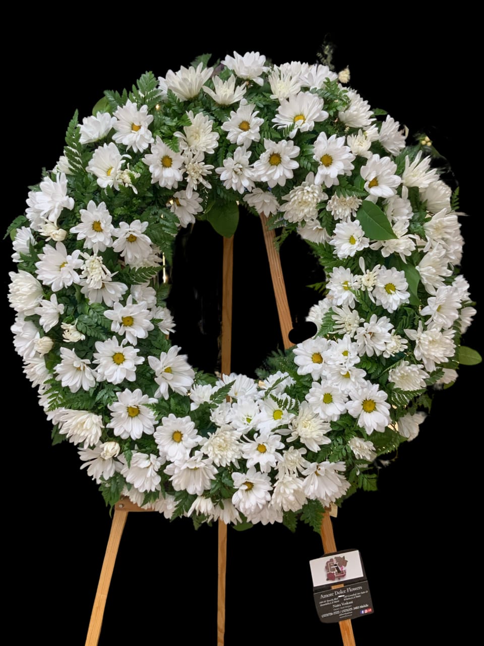 White daisy wreath on a wooden easel