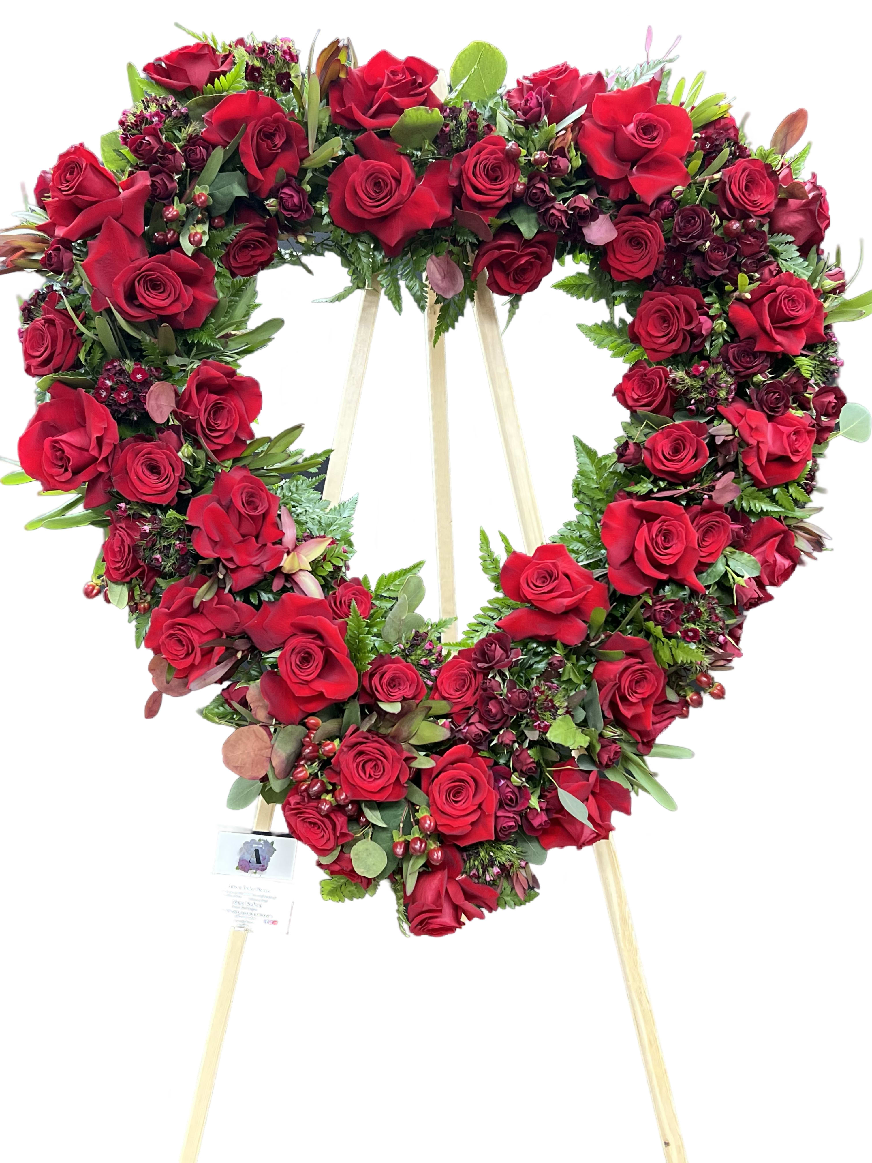 Heart-shaped red rose wreath on a wooden easel