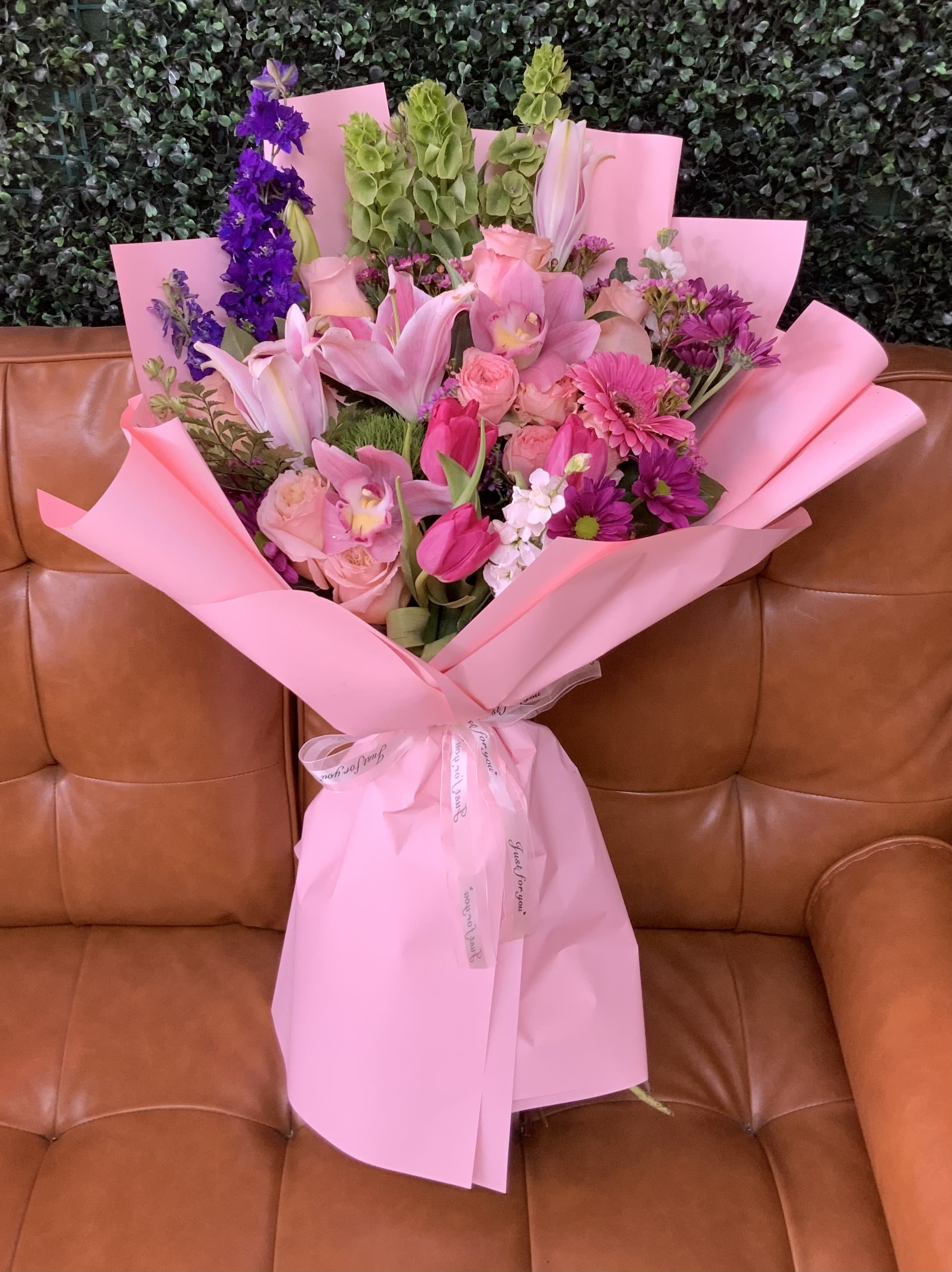 Pink bouquet with lilies, roses, and purple flowers wrapped in pink paper