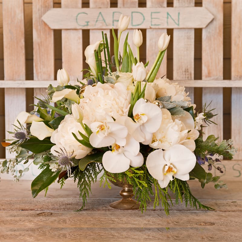White floral arrangement in a low brass vase