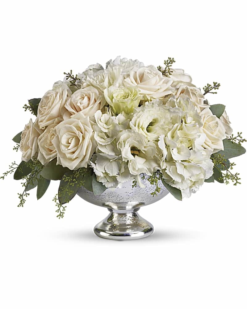 Cream roses and white flowers arranged in a silver pedestal bowl