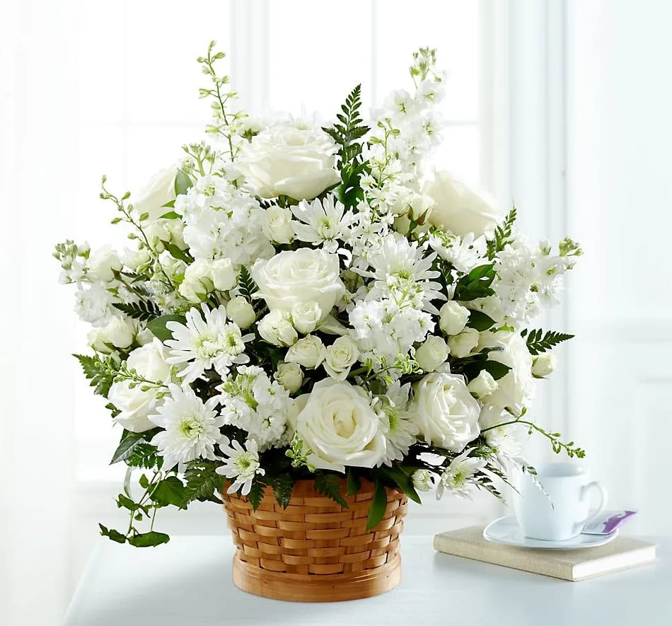 White roses and daisies arranged in a woven basket