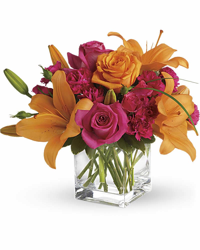Pink roses and orange lilies arranged in a clear glass vase