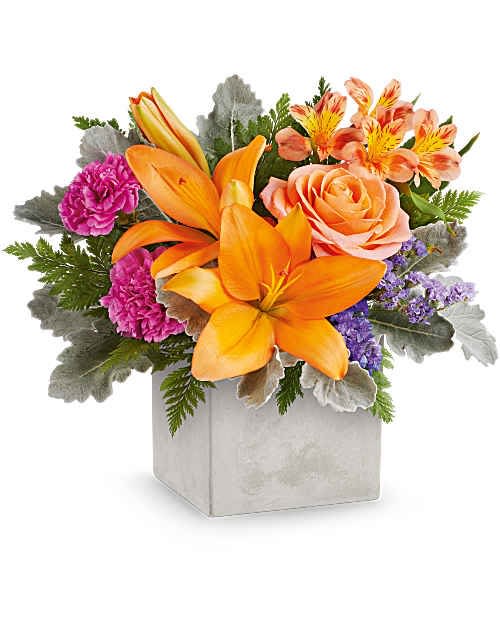 Garden Gem - Bright orange lilies take center stage in this Garden Gem flower arrangement, making it a joyful choice for a birthday bouquet, thank-you gift, or any everyday celebration. The vivid mix of peach roses, magenta carnations, and orange-and-yellow alstroemeria delivers an energetic, warm burst of color, while touches of soft purple filler and silvery foliage add cool contrast so the recipient feels genuinely uplifted and seen. 